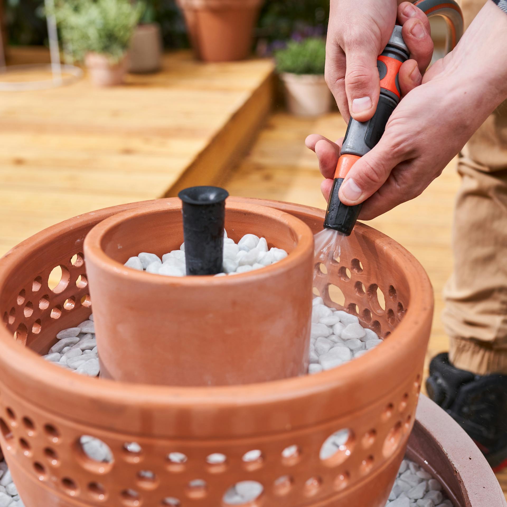 Wasserspiel wird mit dem Gartenschlauch befüllt.