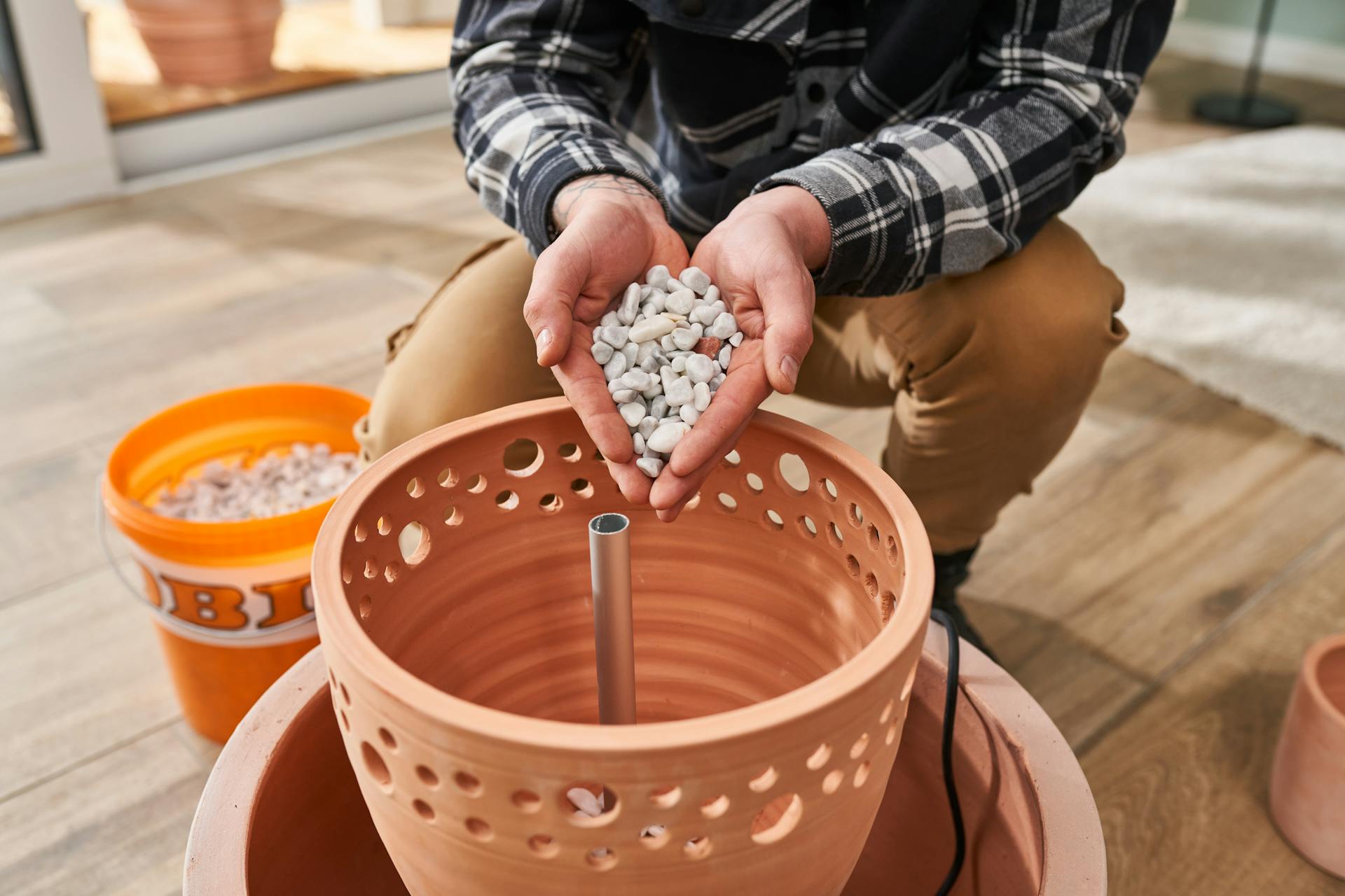 La ghiaia decorativa viene inserita manualmente nel vaso
