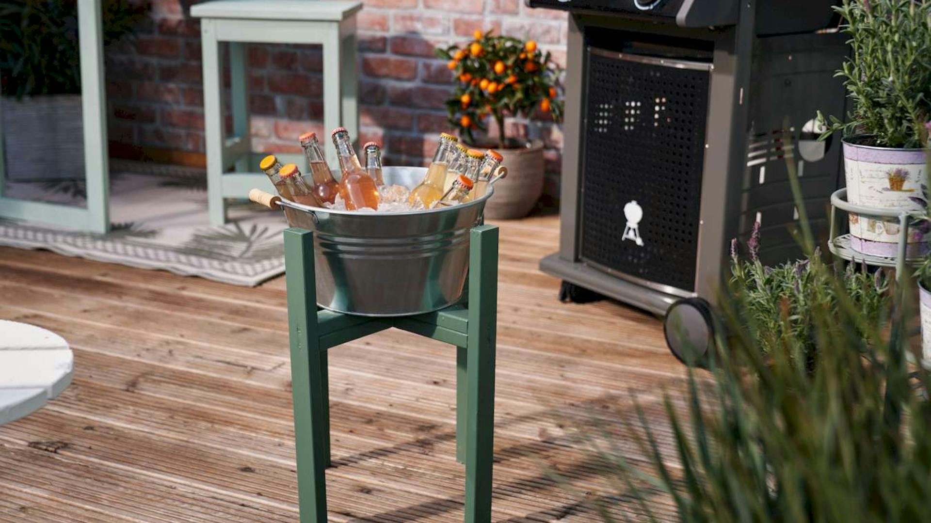 Eine selbstgebaute Getränkekühlung steht auf einer Terrasse.