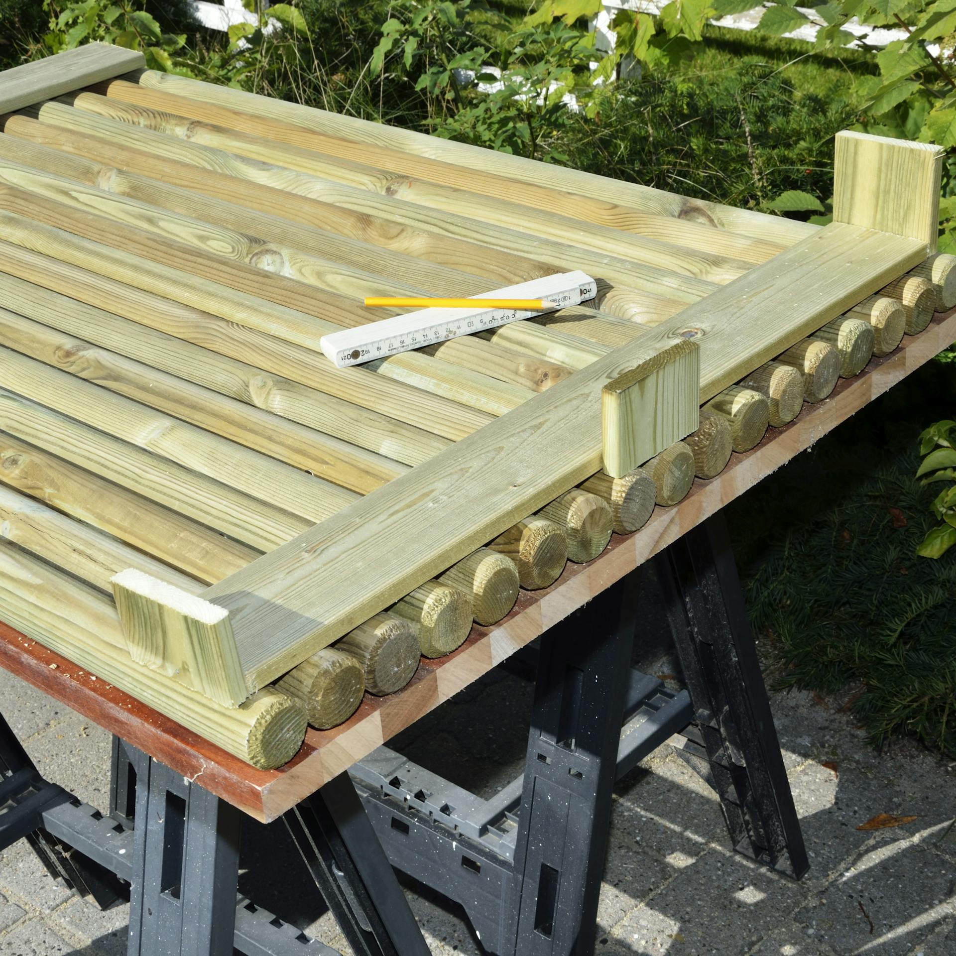 Priskrutkujte priečnu latu na drevené stĺpiky boxu na smetnú nádobu