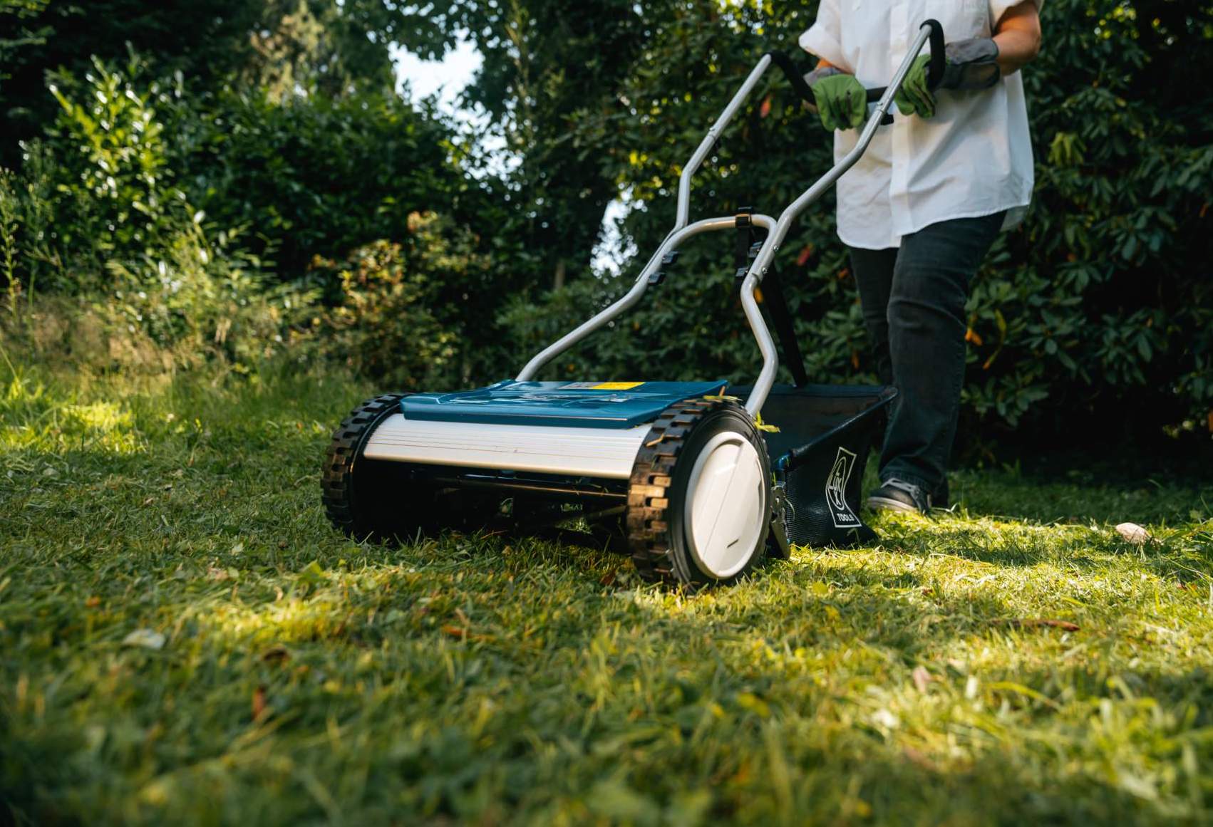 Férfi füvet nyír kézi fűnyíróval 