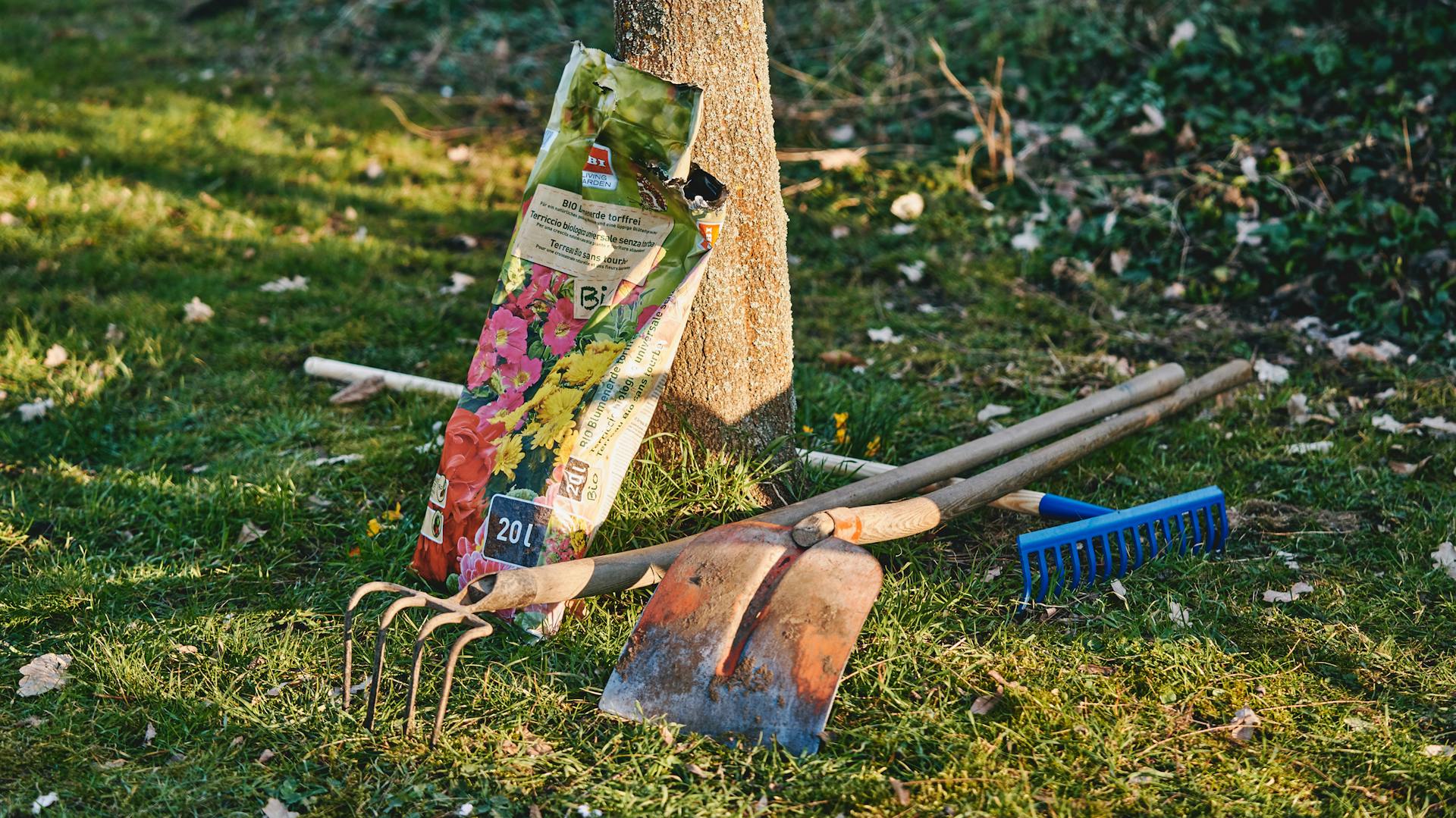 Gartenwerkzeug auf Rasen in naturnahem Garten