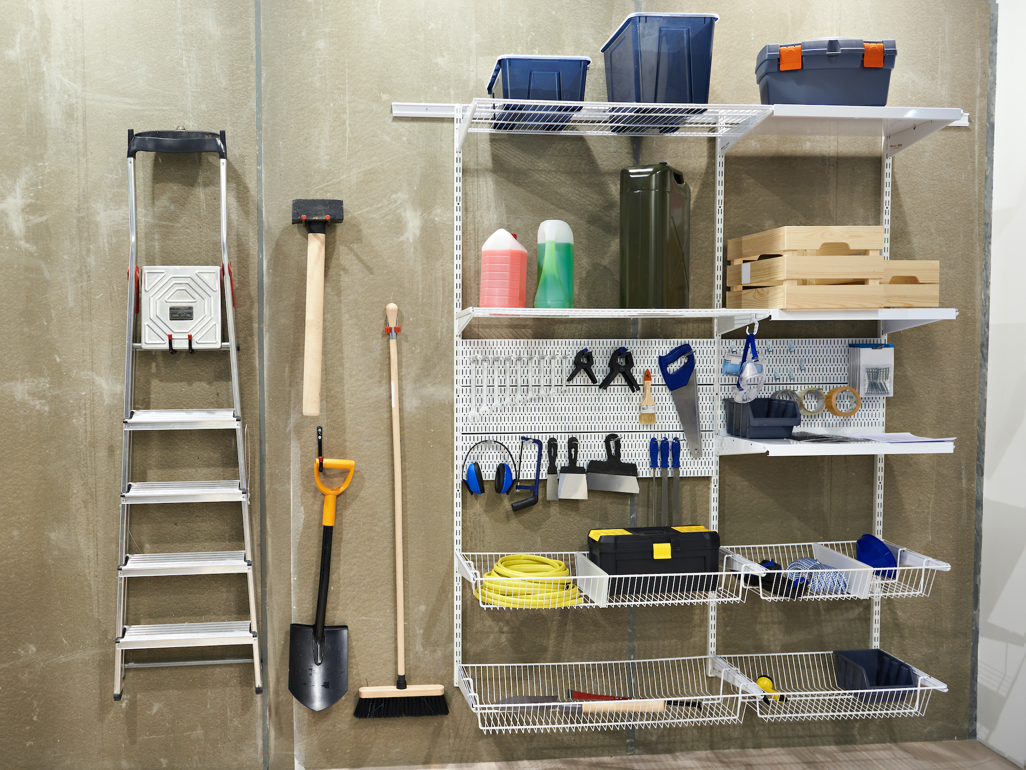 Attrezzi da giardino ordinati accanto a scaffali con utensili e piccoli oggetti in scatole