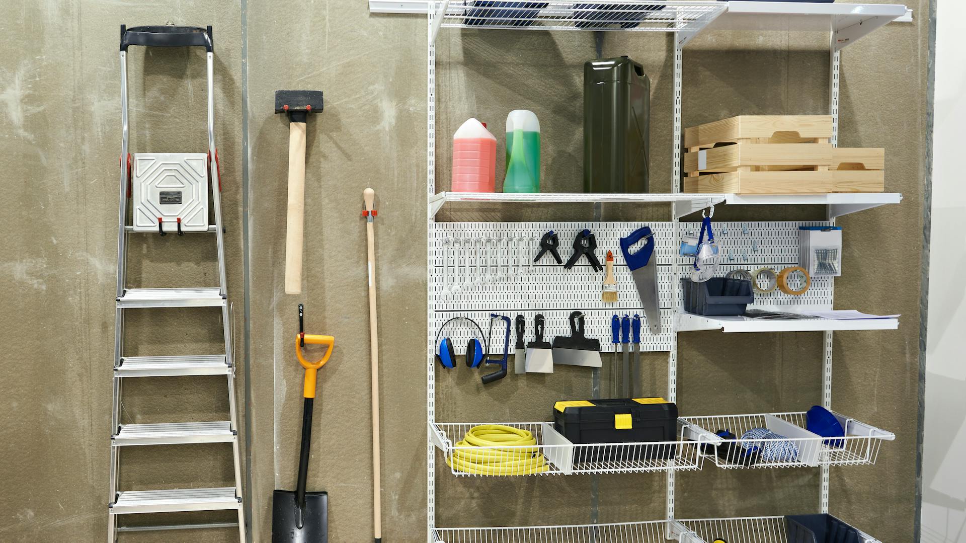 Attrezzi da giardino ordinati accanto a scaffali con utensili e piccoli oggetti in scatole
