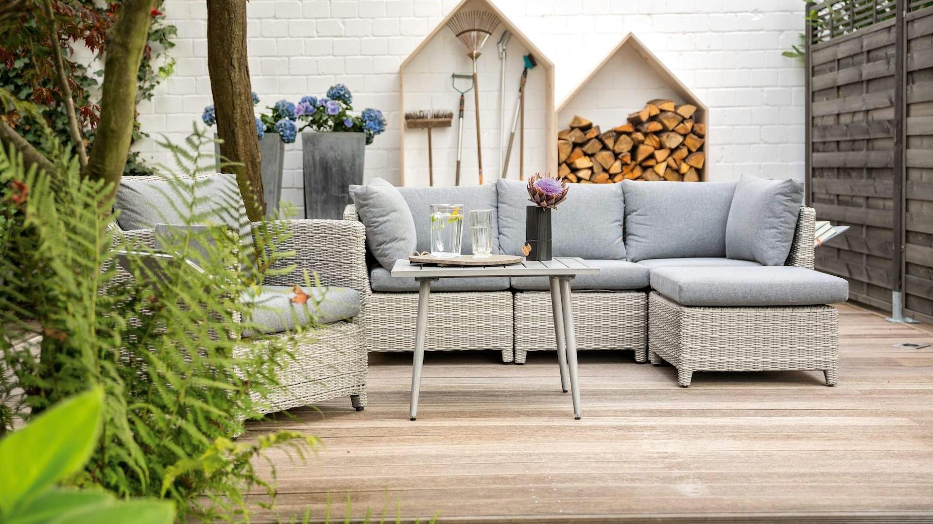 Ordnung im Garten: Aufgeräumte Terrasse mit Werkzeugen und Sitzecke im Hintergrund