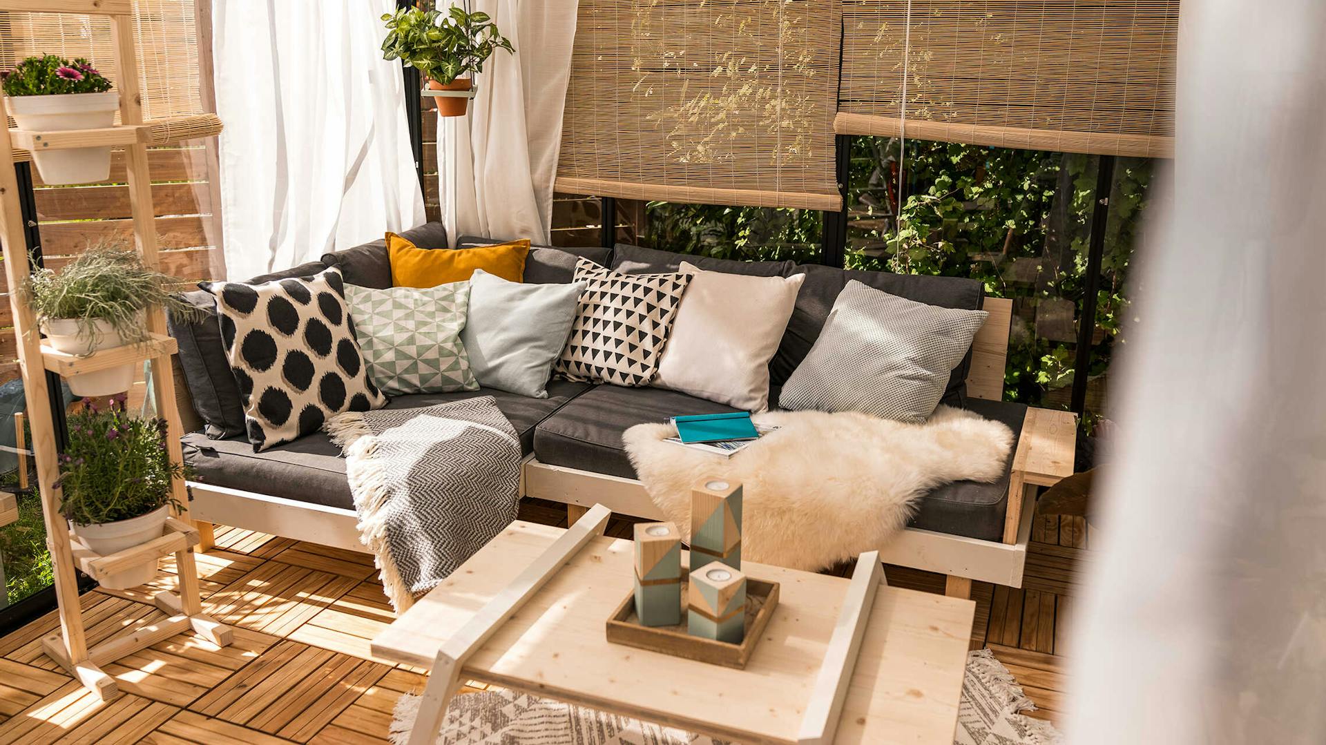 Loungemöbel Kiluja auf einer gemütlichen Terrasse mit Pflanzbank Flora und Couchtisch Philip.