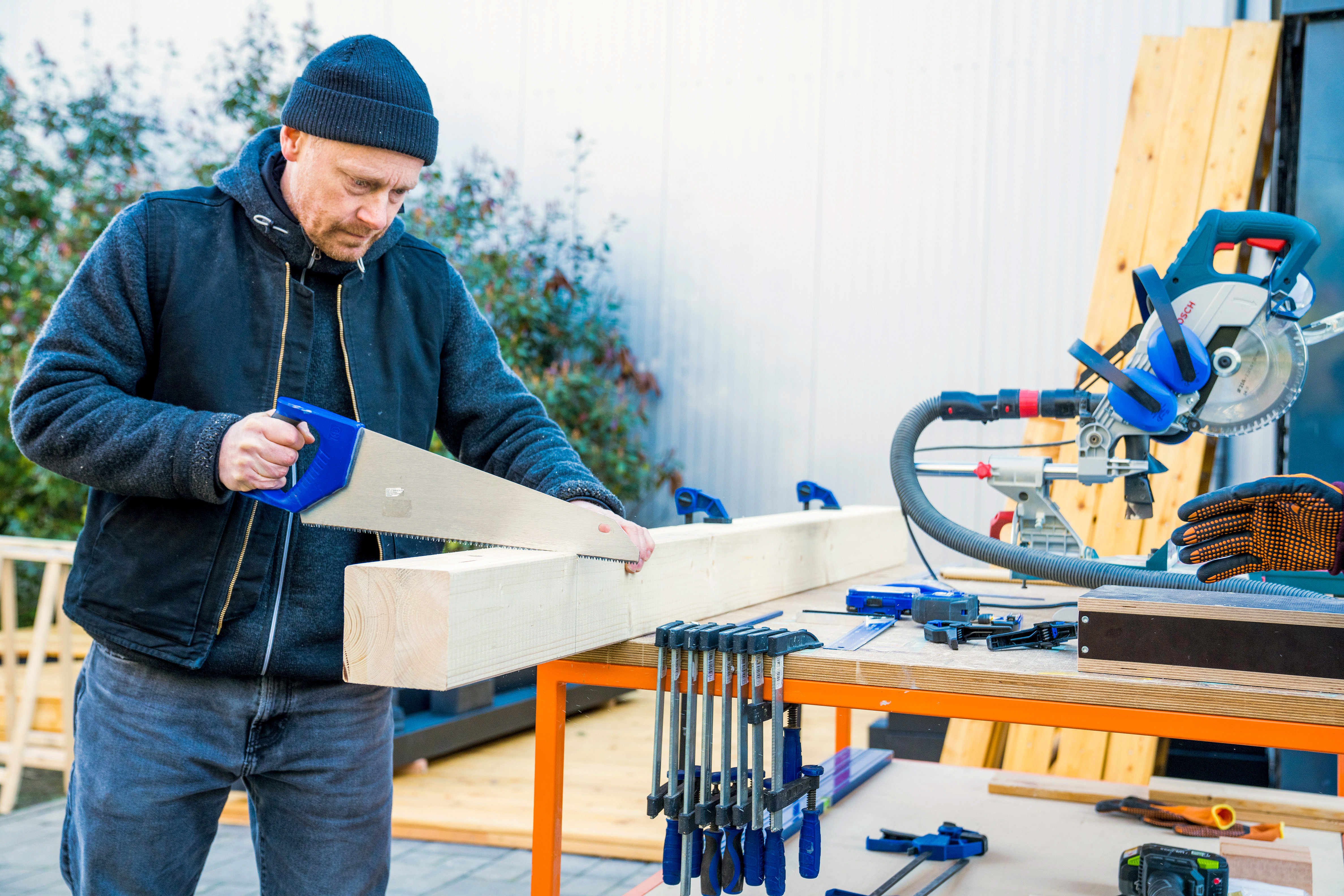 Mann sägt Balken zu