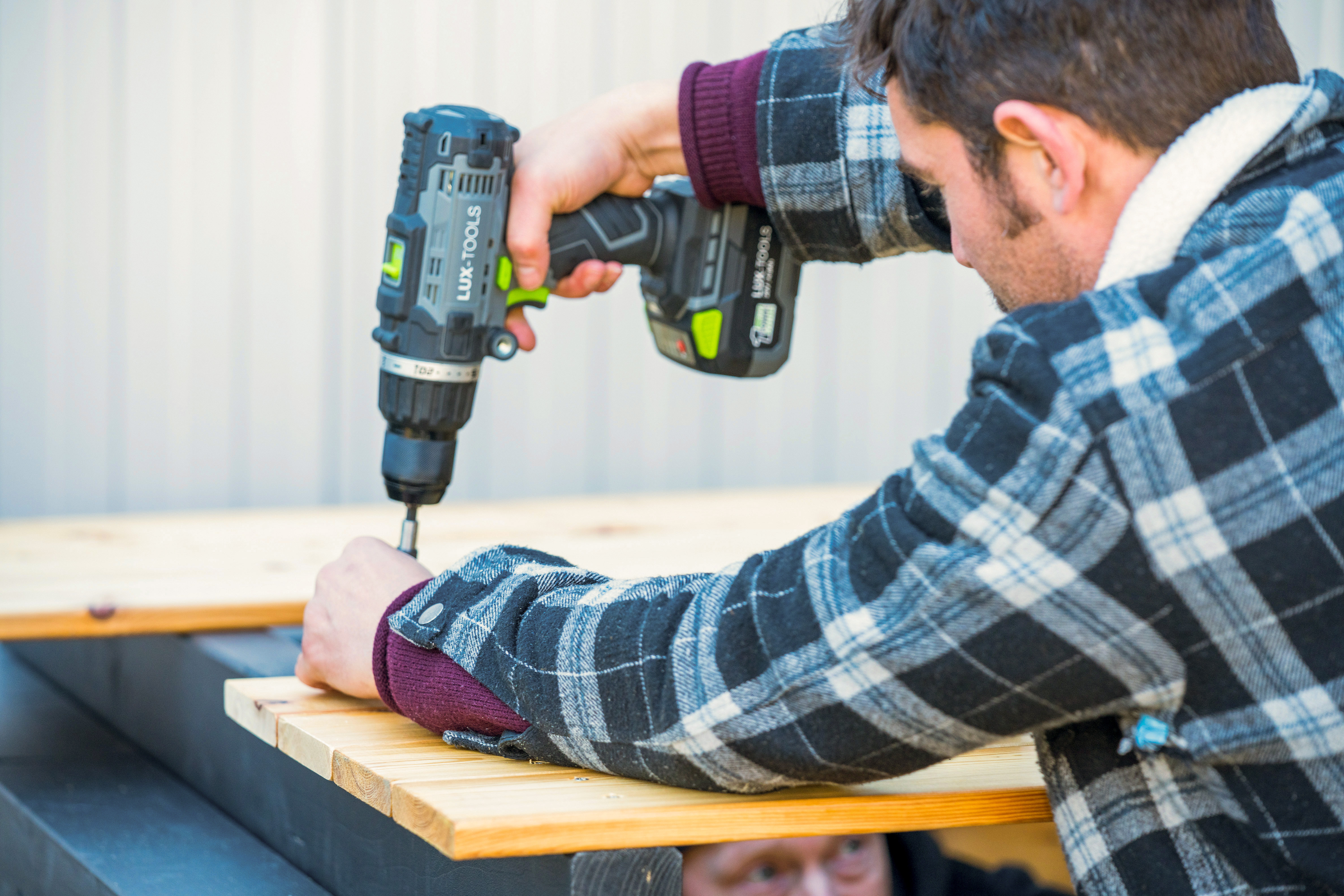 Heimwerker schraubt Latte auf das Dach