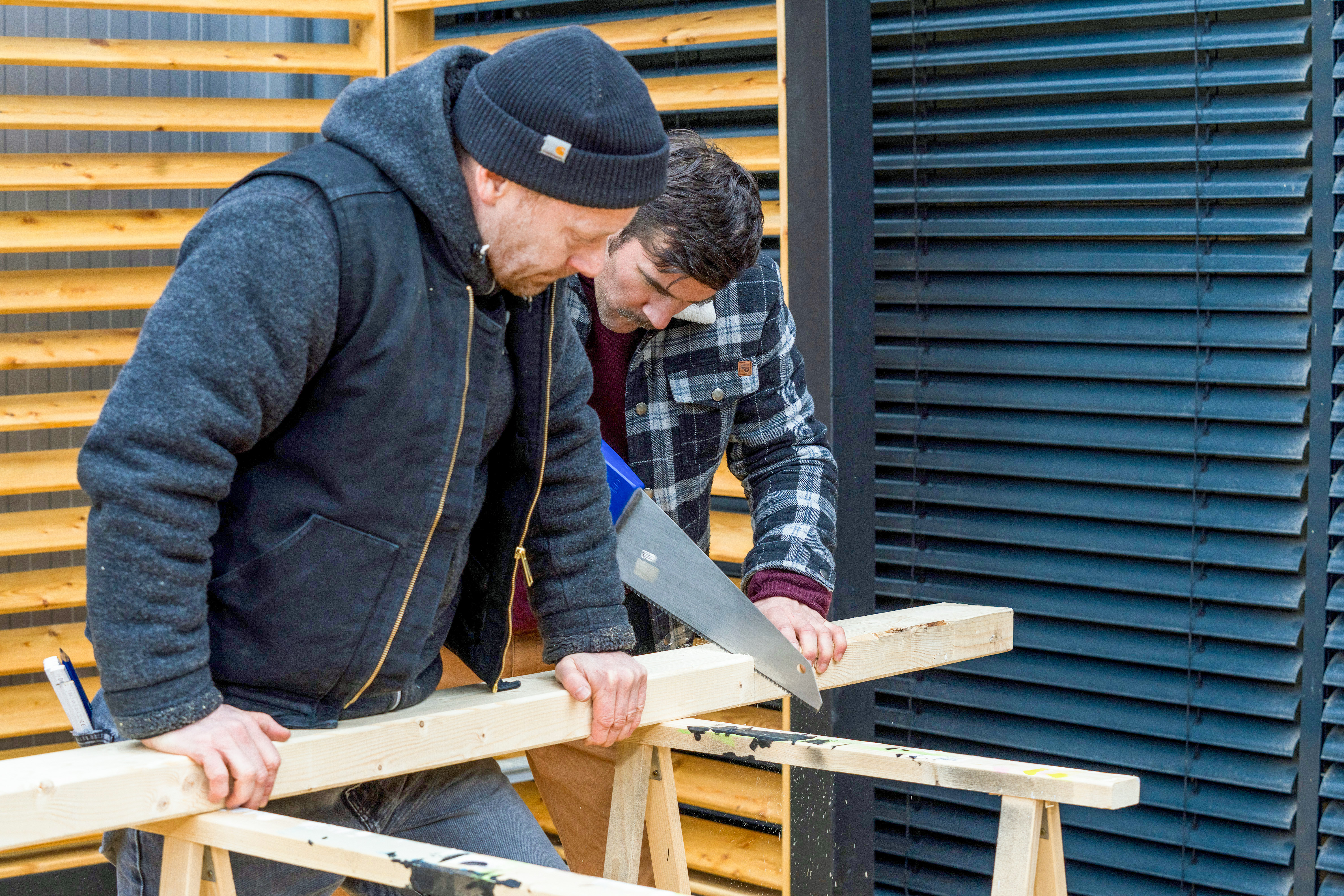 Zwei Heimwerker sägen Sparren zu