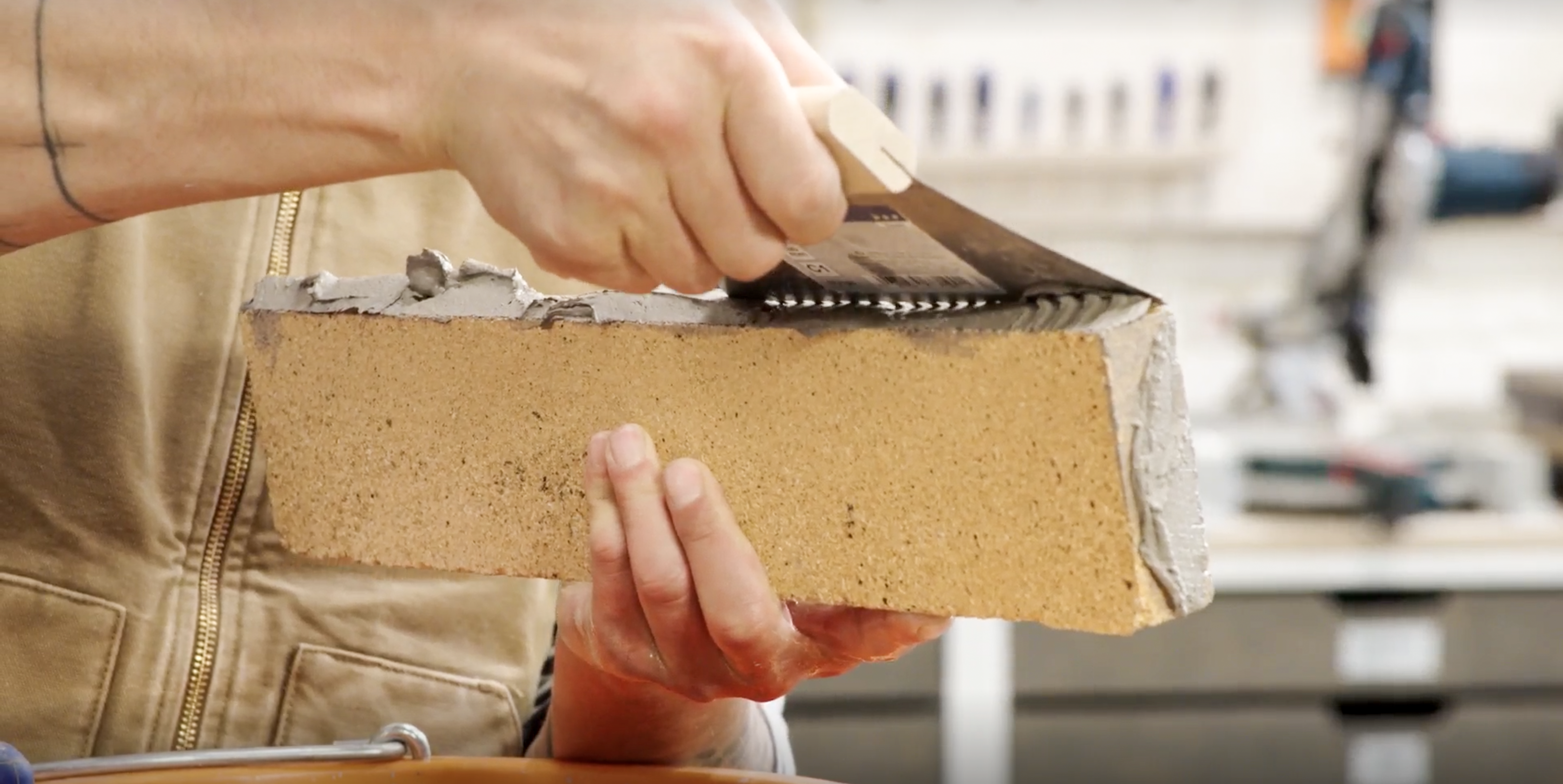 Odstranění přebytečné malty z cihly zubovou stěrkou.