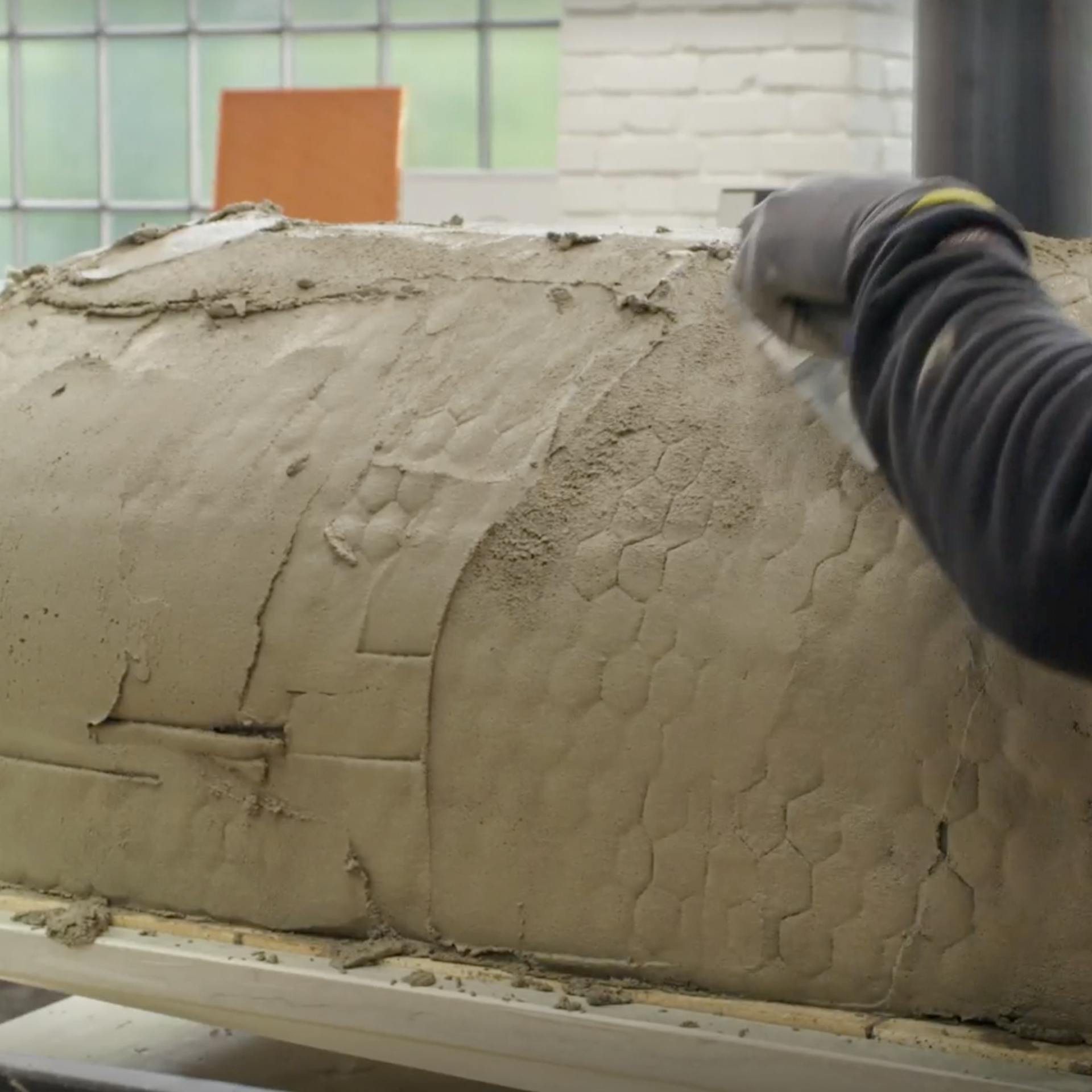 Omítání pece maltou pomocí hladítka.