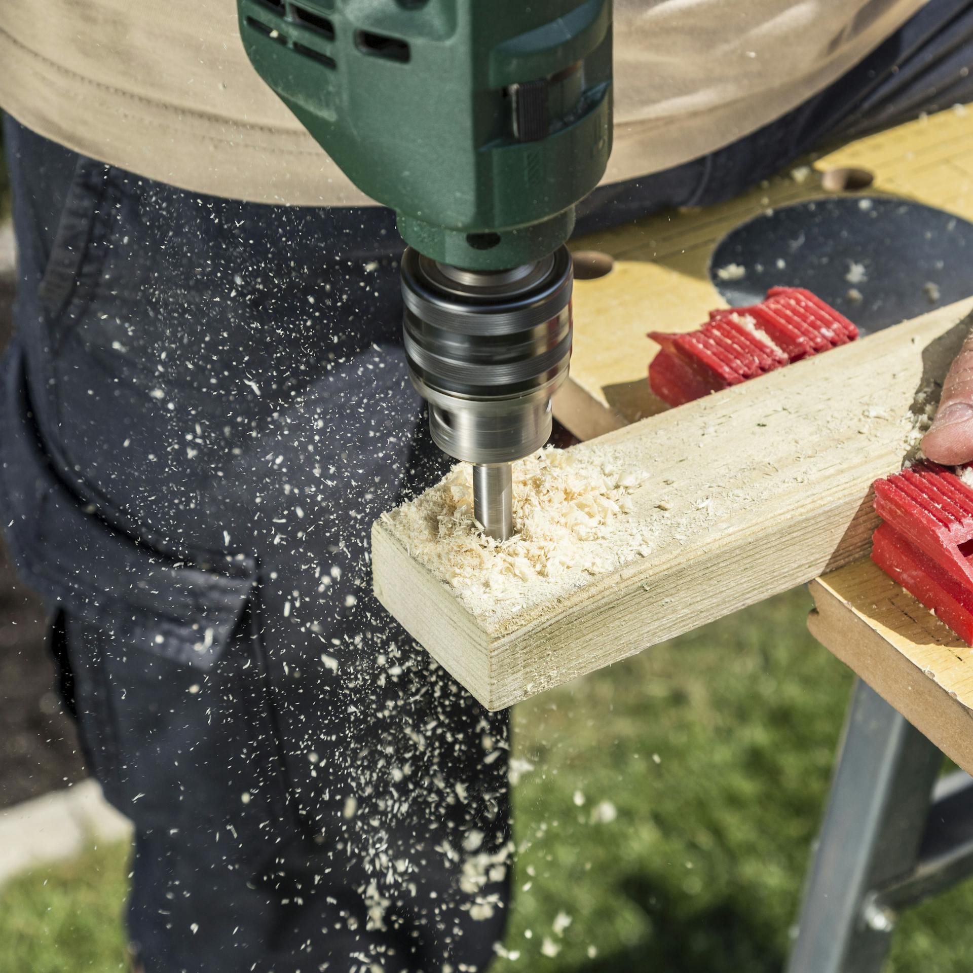 Jemand bohrt ein Loch in eine Querstrebe.