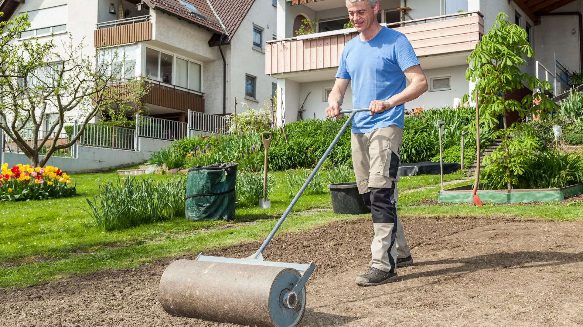 Mann schieb Rasenwalze über Boden
