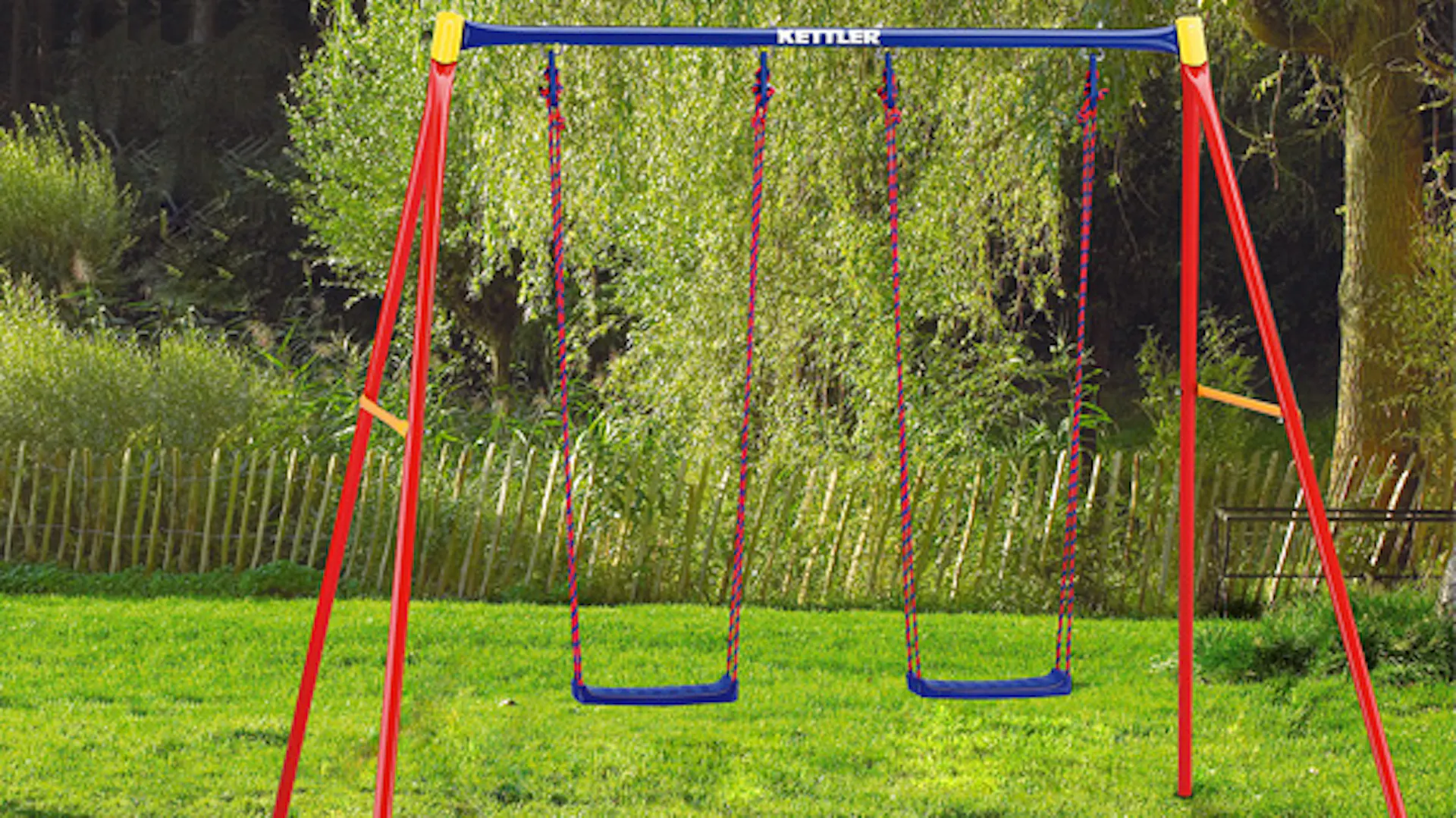 Due altalene con impalcature di metallo rosse in giardino.