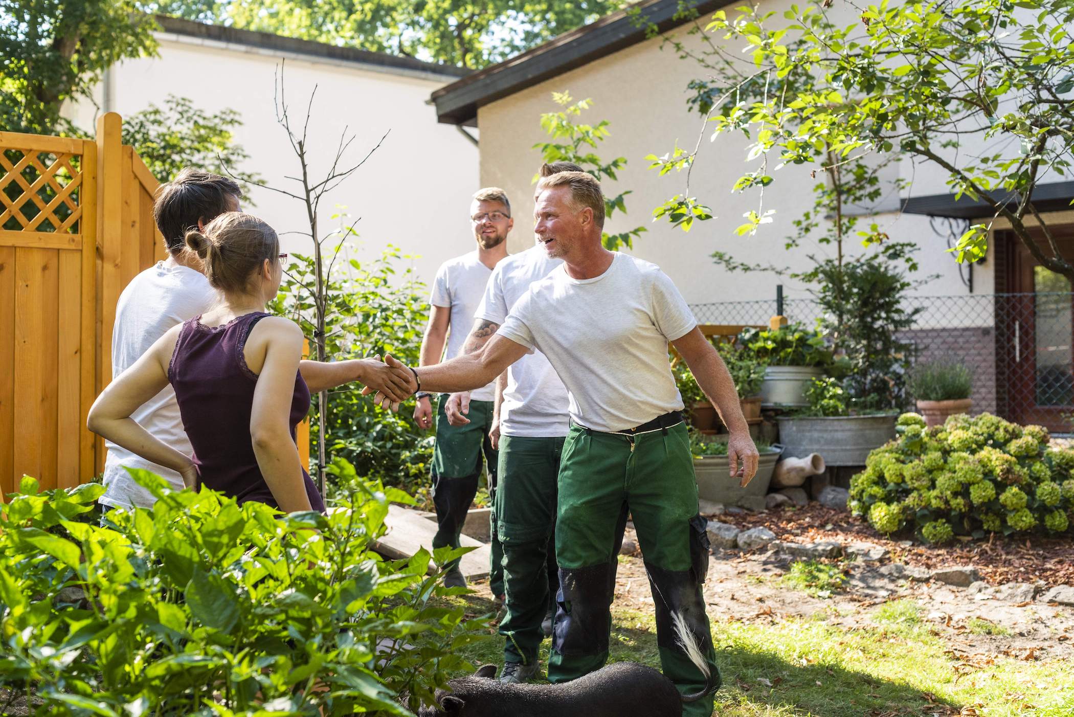 Handwerker und Kunden schütteln sich die Hände.