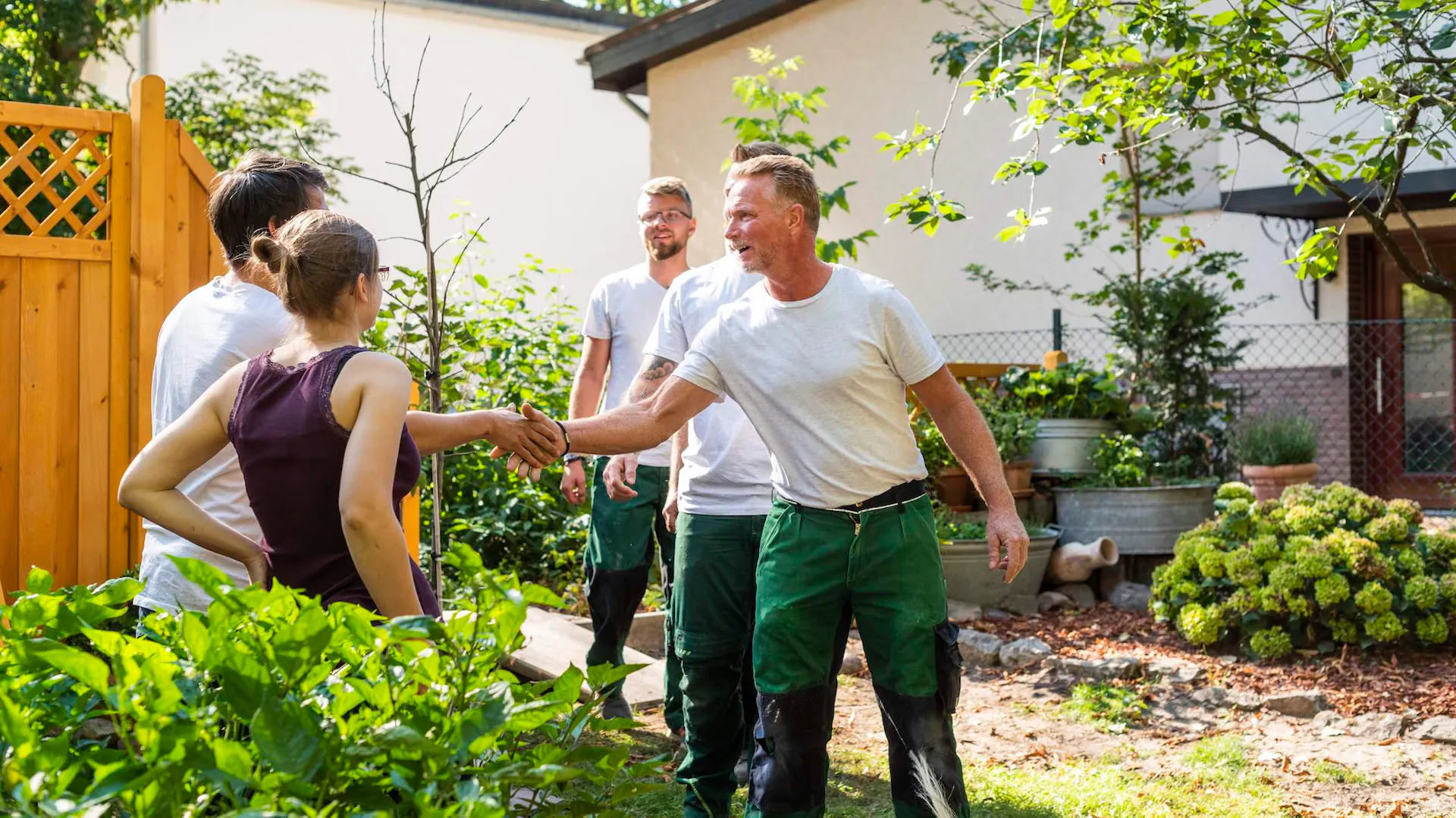 Handwerker und Kunden schütteln sich die Hände.