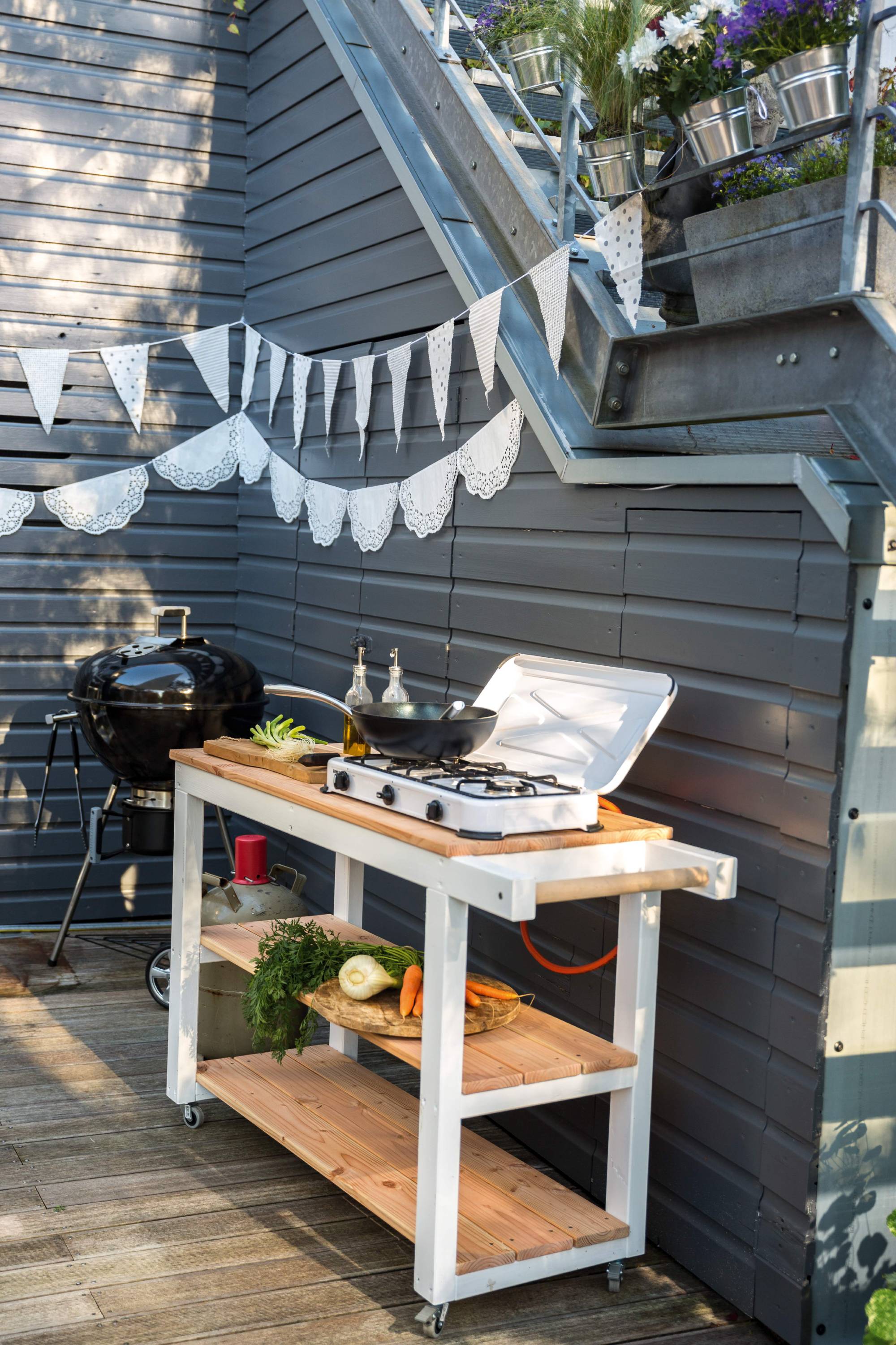 Cucina esterna accanto al grill a parete in giardino