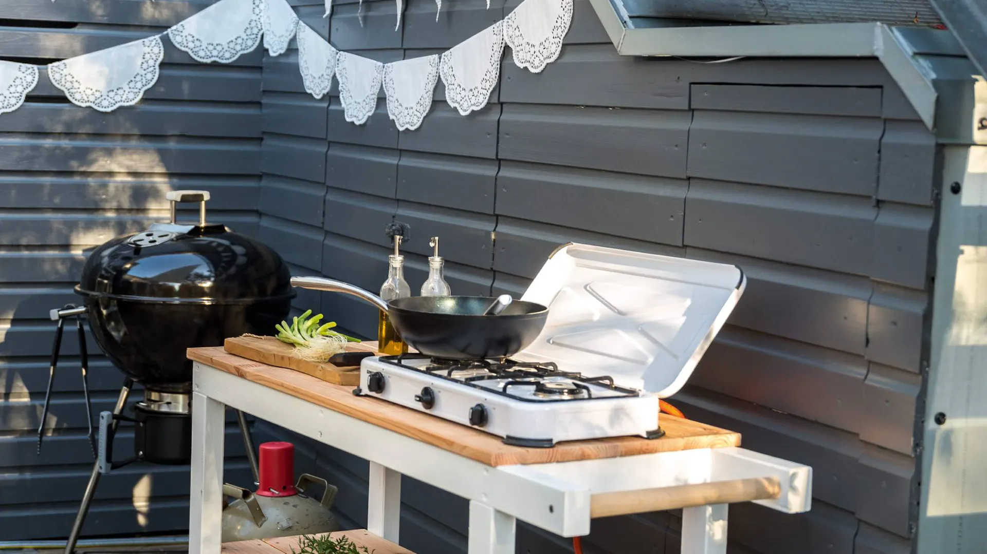 Cucina esterna accanto al grill a parete in giardino