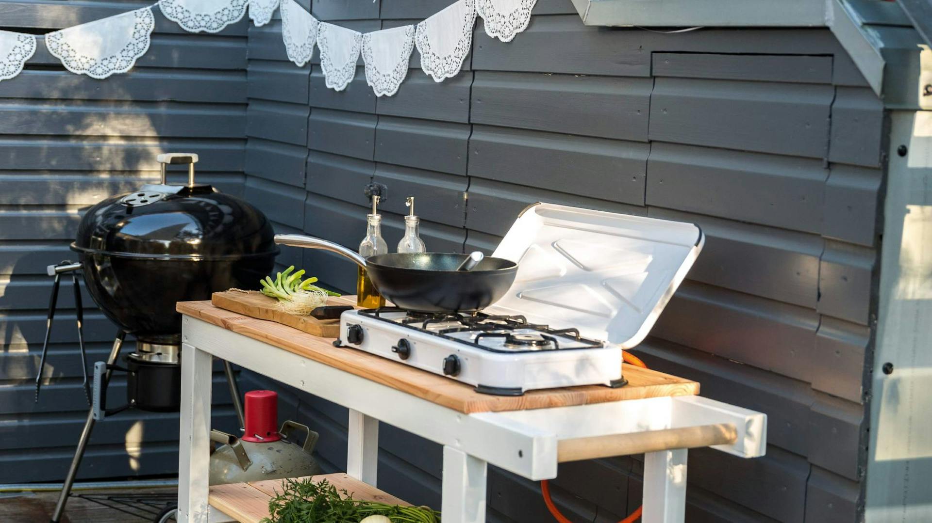 Cucina esterna accanto al grill a parete in giardino