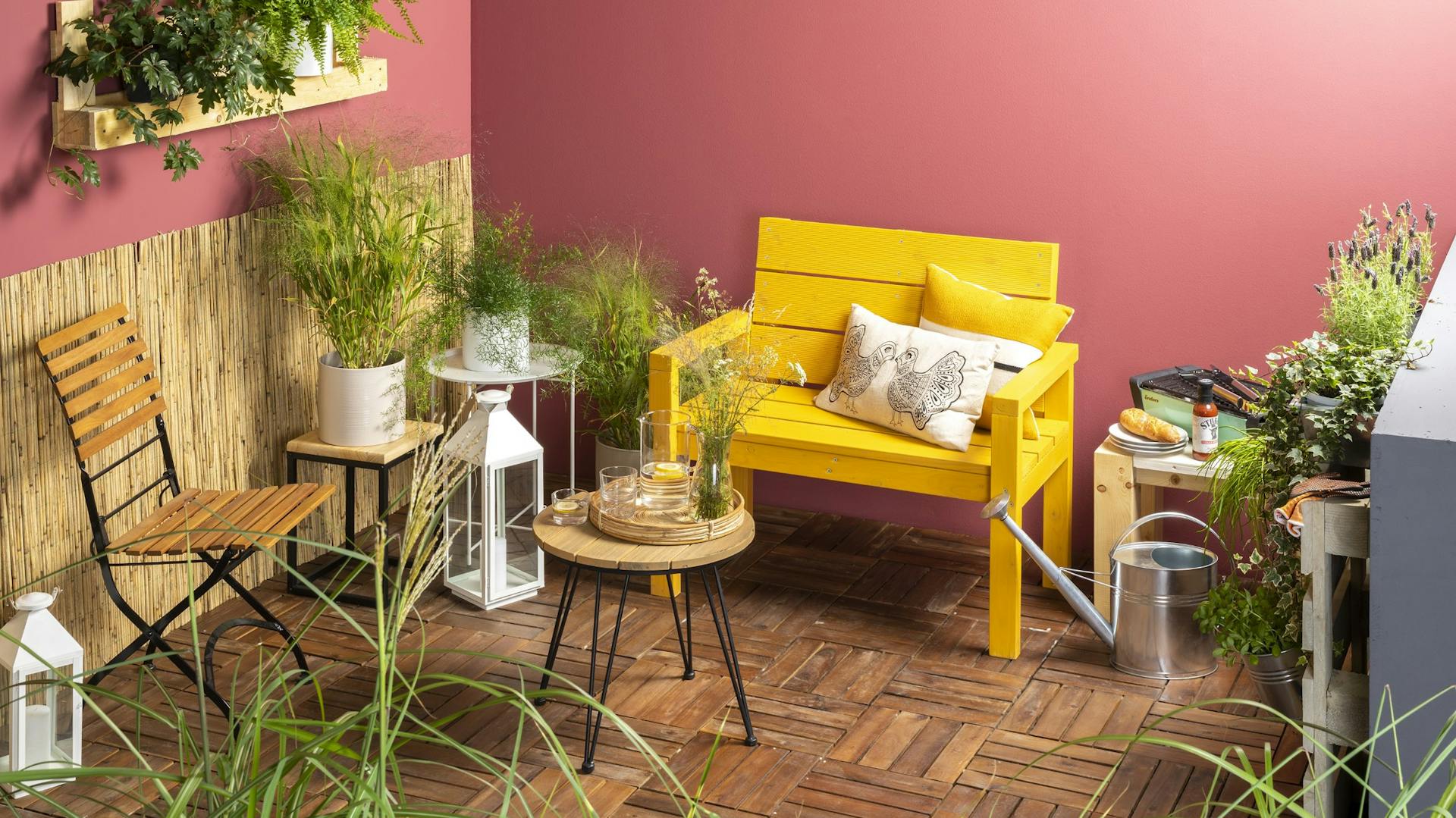 Panca fai da te gialla monoposto, su una terrazza circondata da piante in vaso, sedia e tavolino