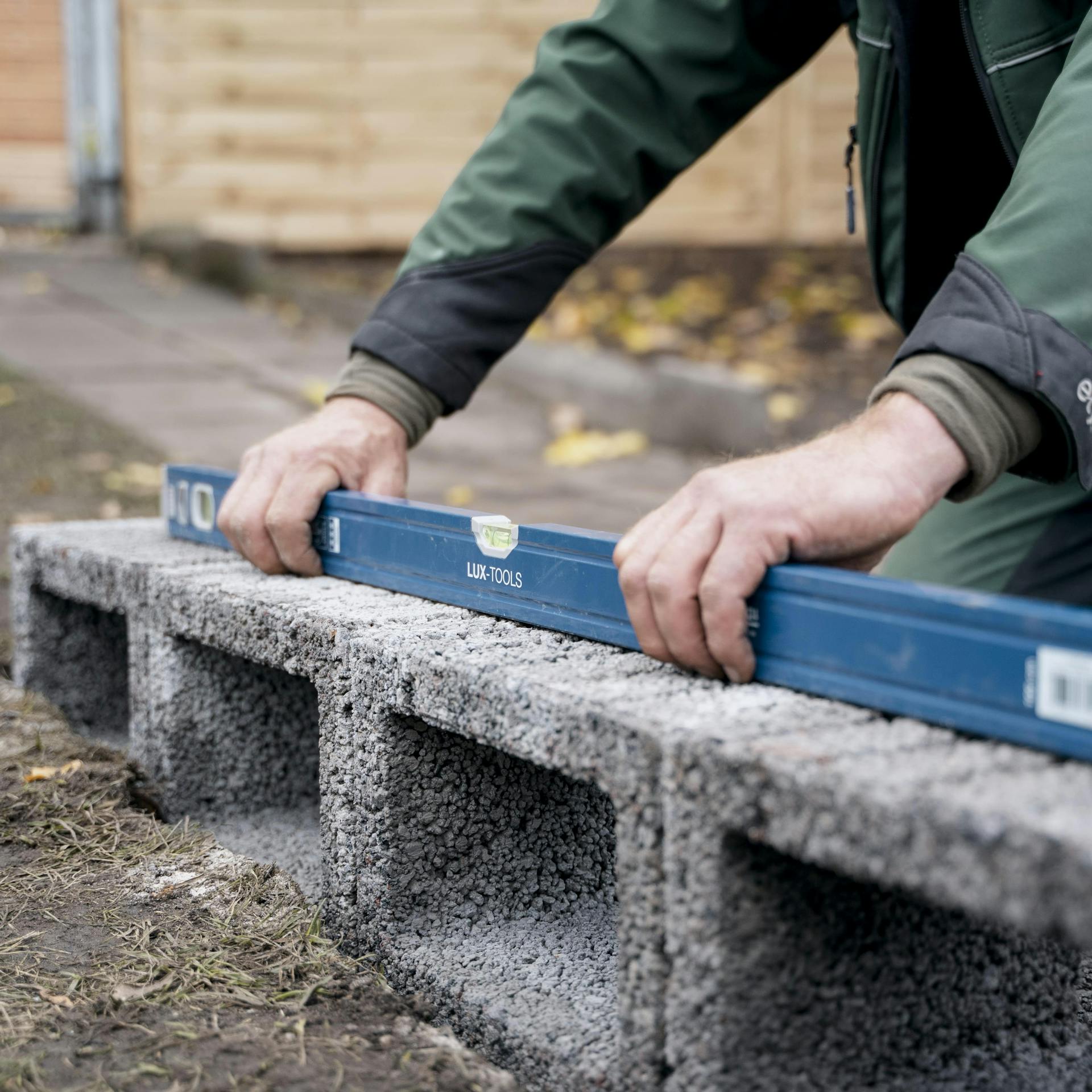 Heimwerker misst Pflanzsteine aus.