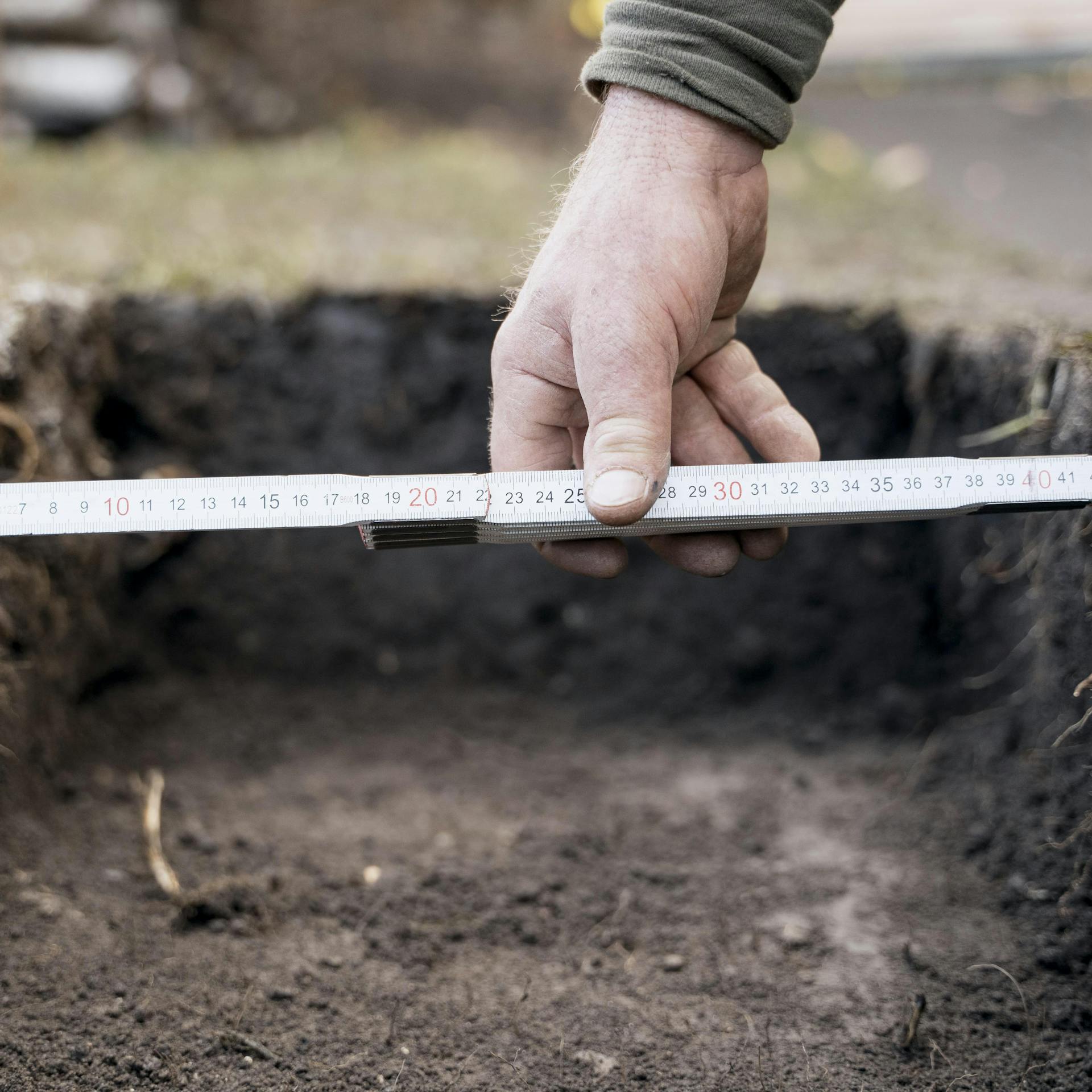 Heimwerker misst eine Ausschachtung aus.