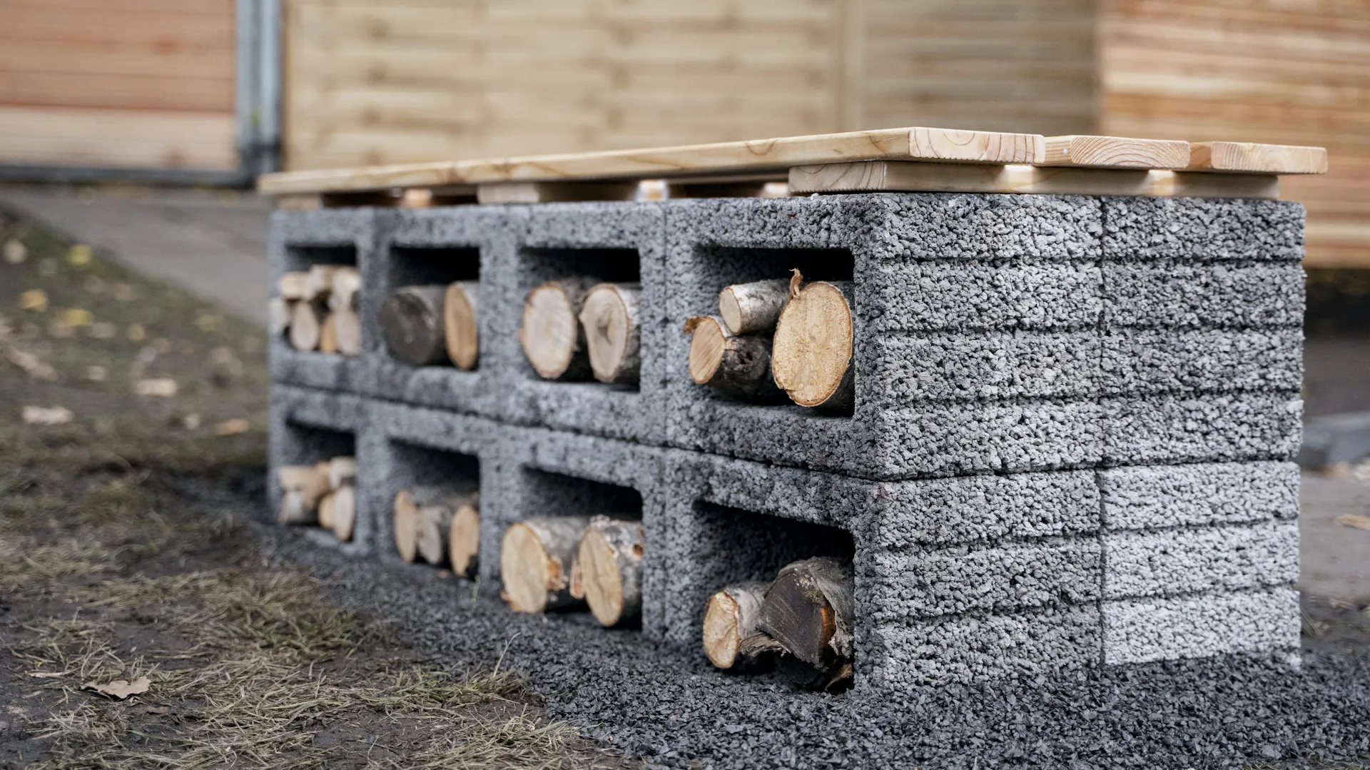 Sitzmauer mit Holzlager im Garten