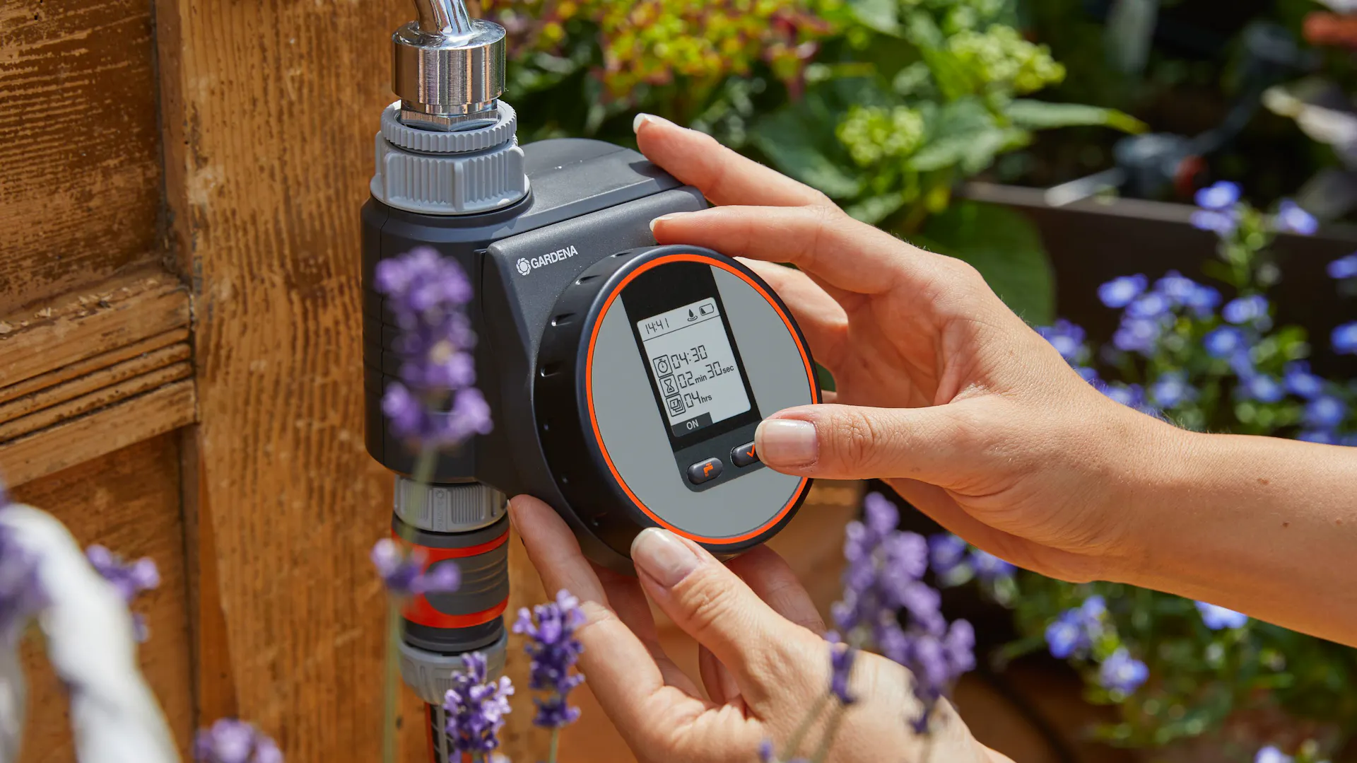 Person bedient Bewässerungscomputer zur automatischen Gartenbewässerung.