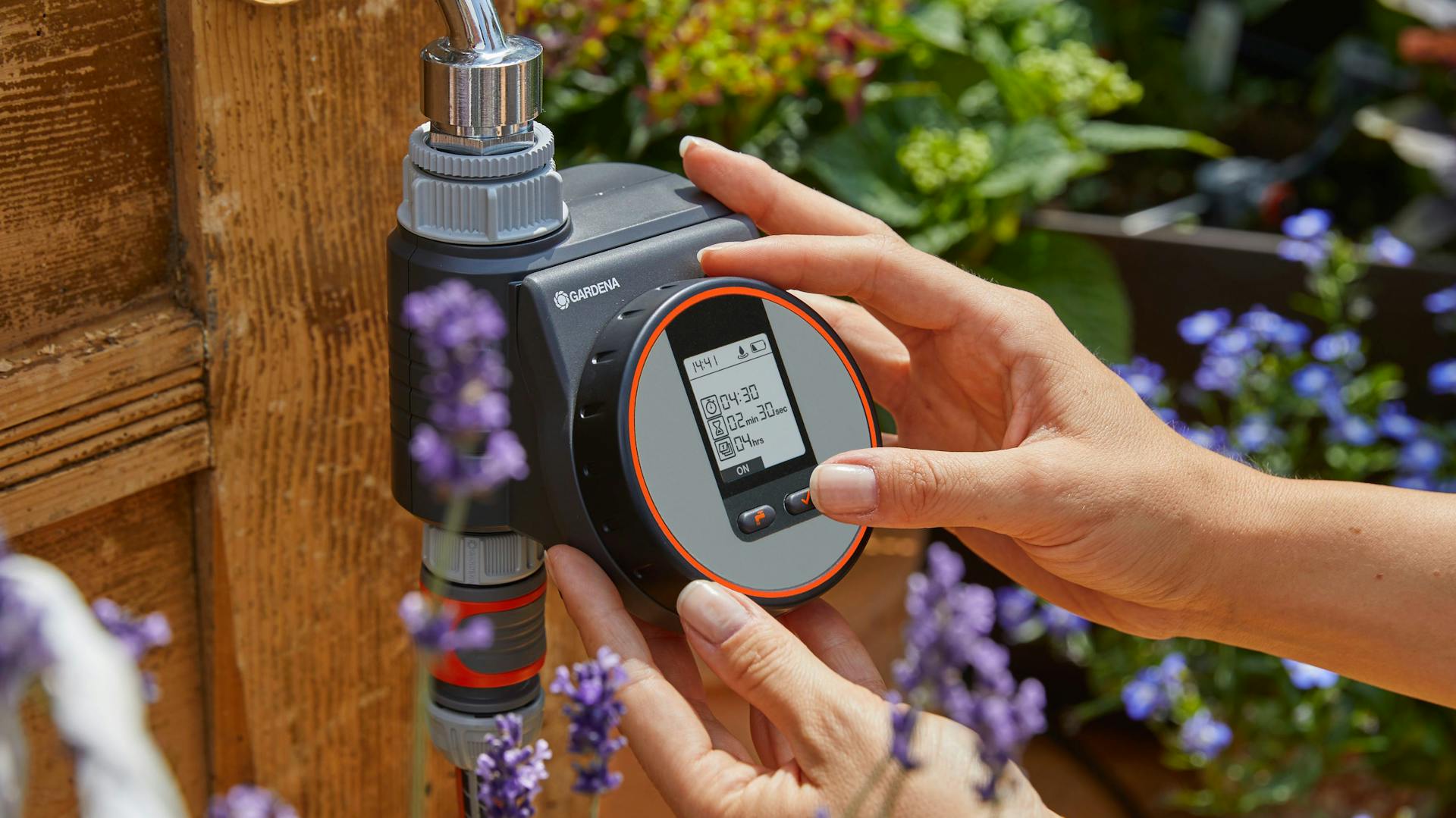 Hände stellen Bewässerungscomputer ein