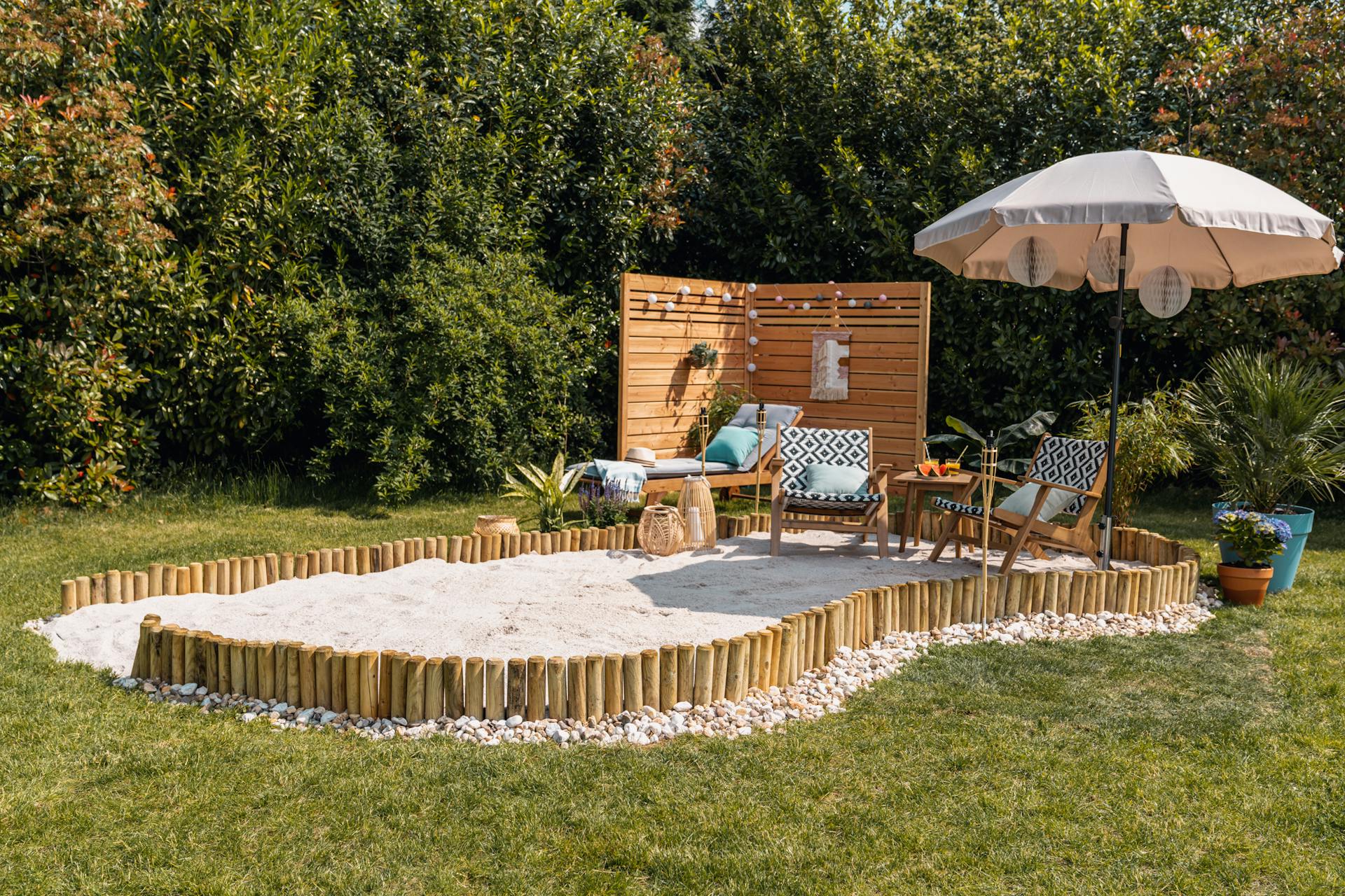 Familie in einem Sandkasten mit Schirm und Sonnenliege