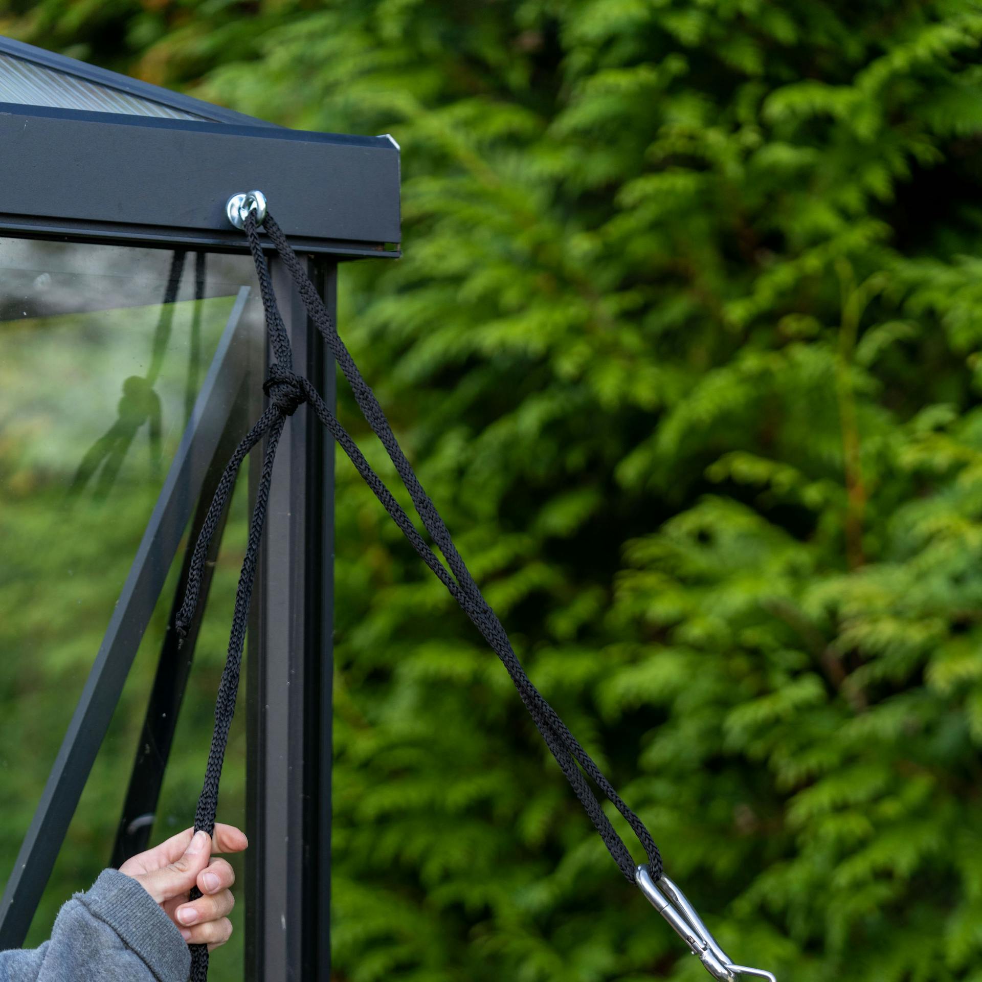 Sonnensegel wird an einem Gartenhaus fixiert