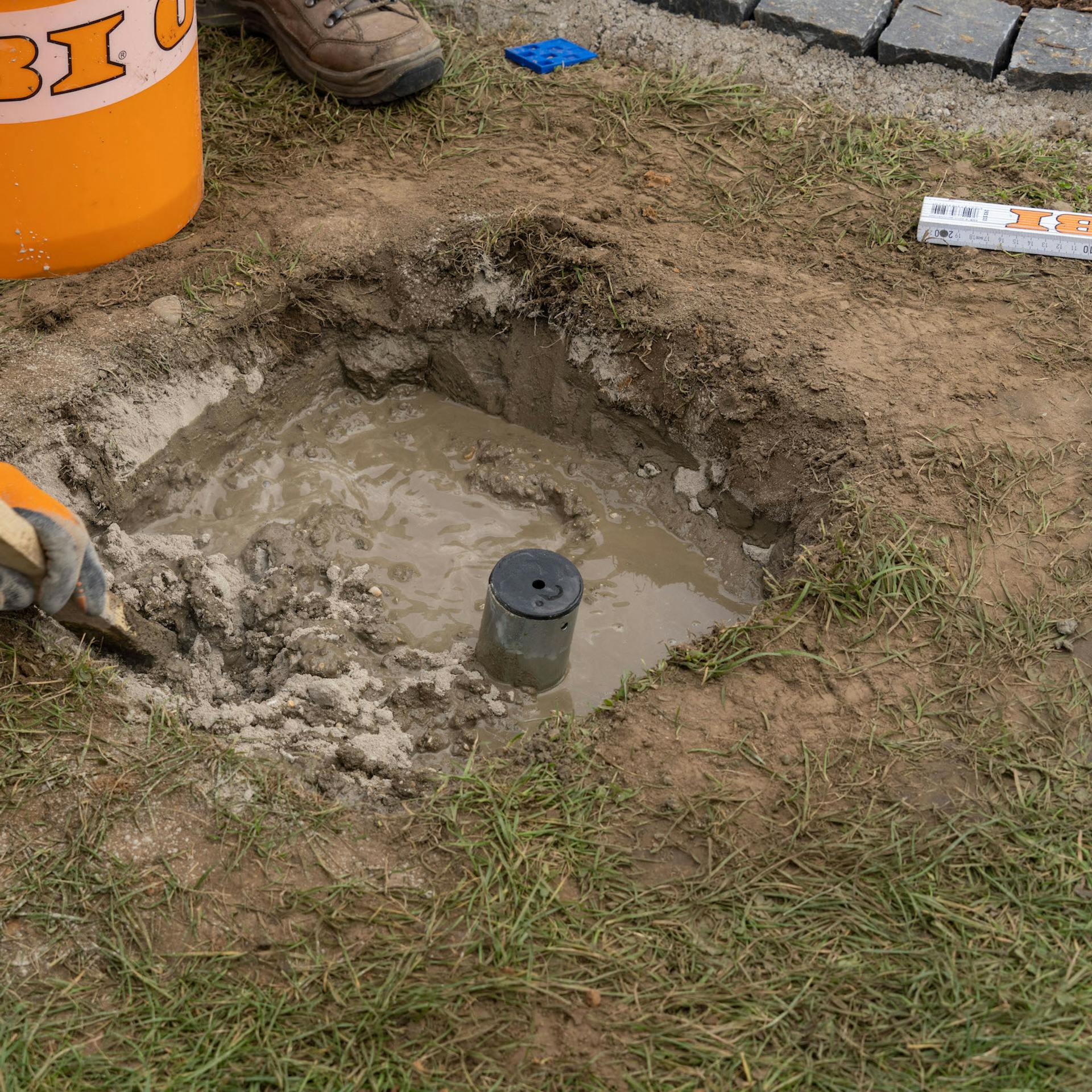Beton wird in ein Erdloch geschüttet