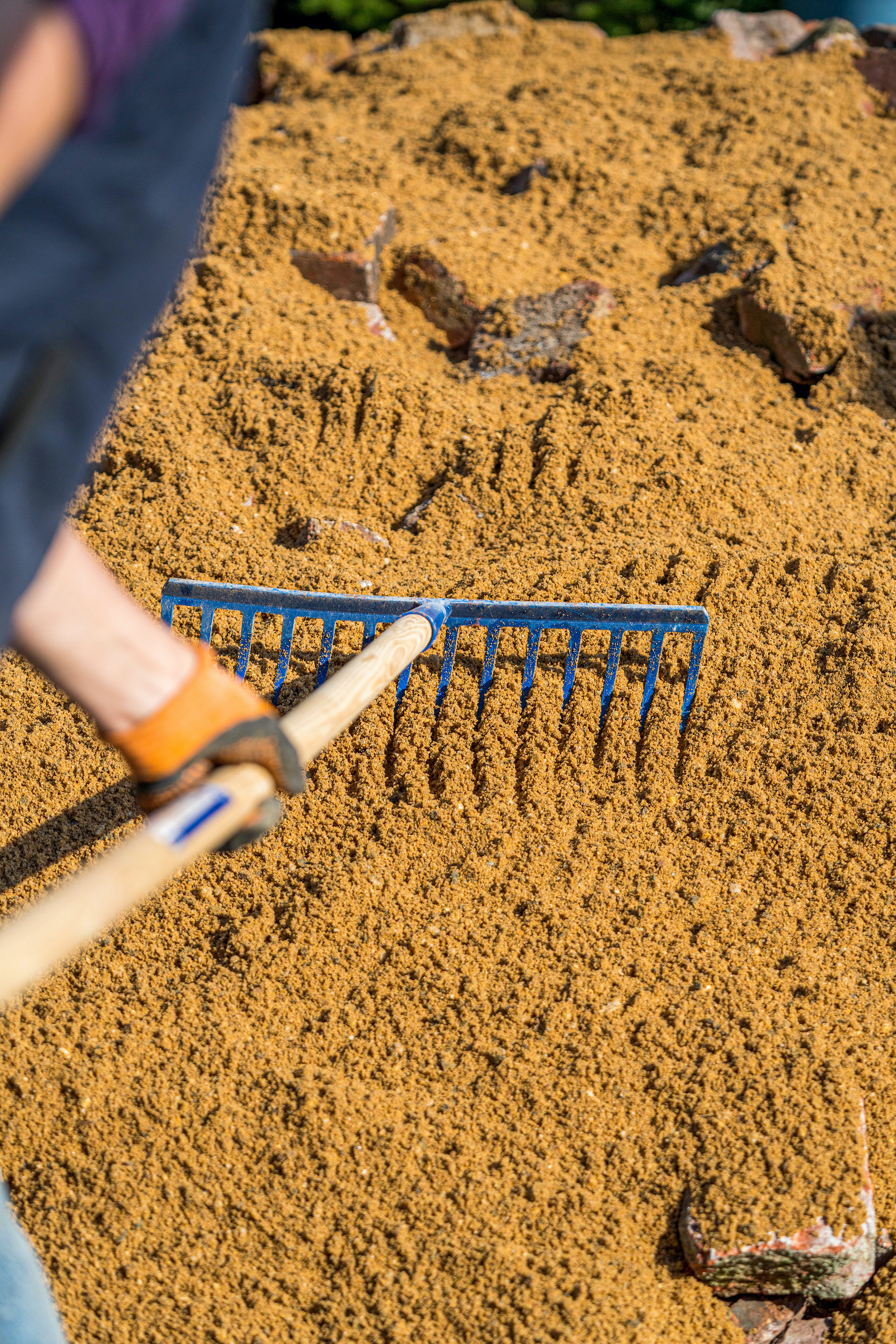 Piesok sa rovnomerne rozmiestňuje hrabľami