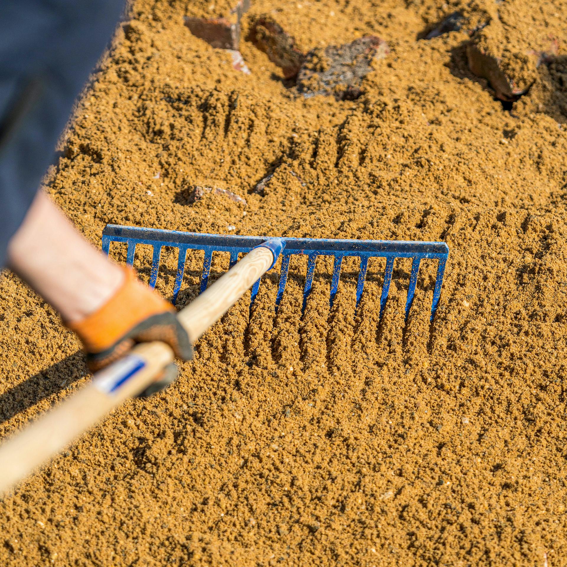 Piesok sa rovnomerne rozmiestňuje hrabľami