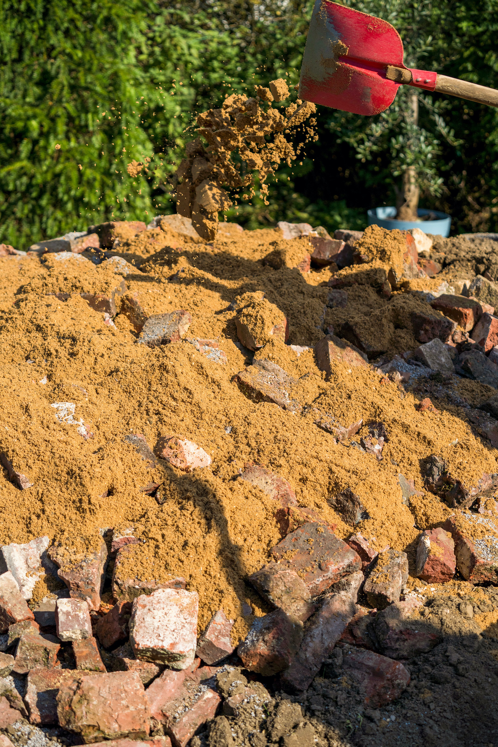 Rozsýpanie piesku na úlomky tehál