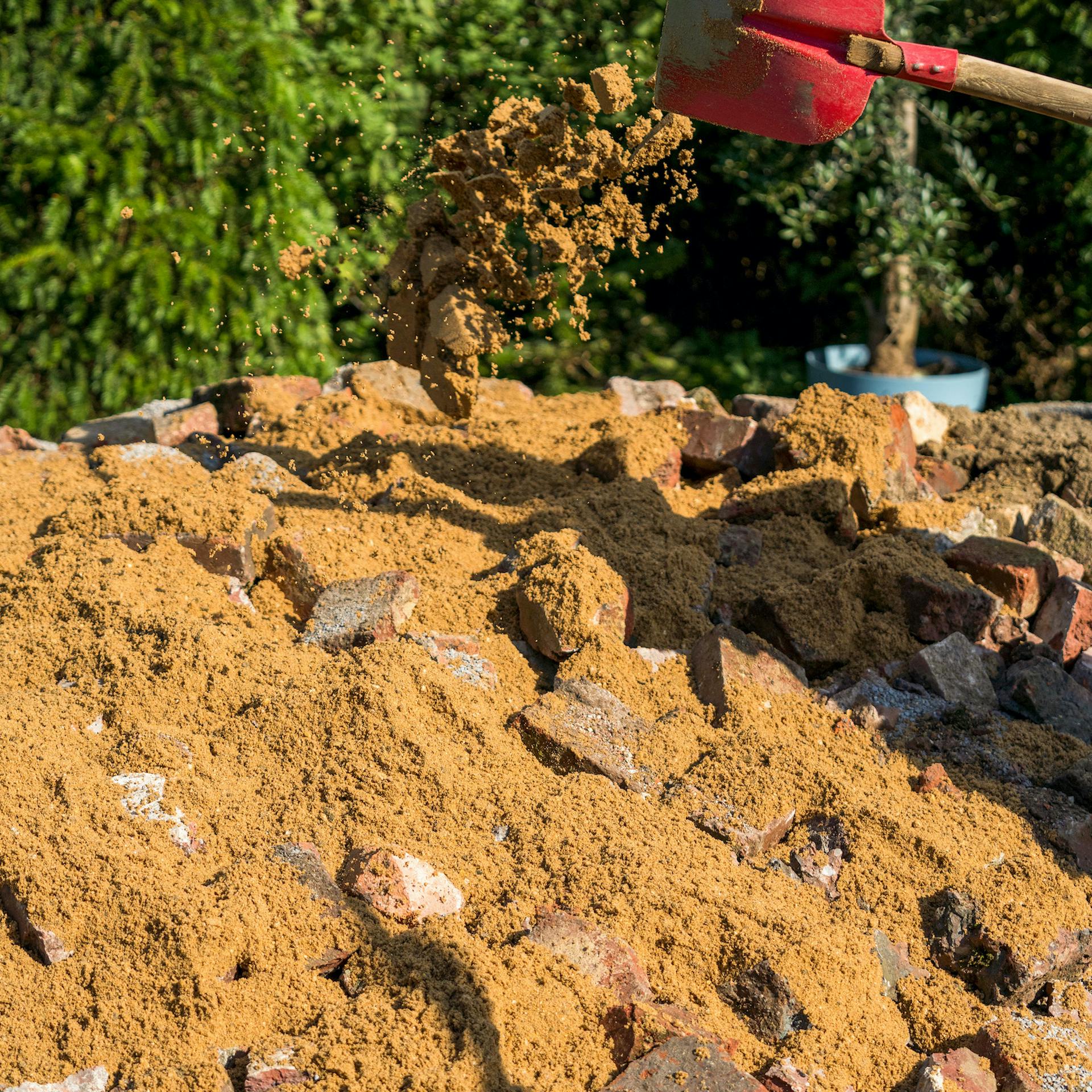 Rozsýpanie piesku na úlomky tehál