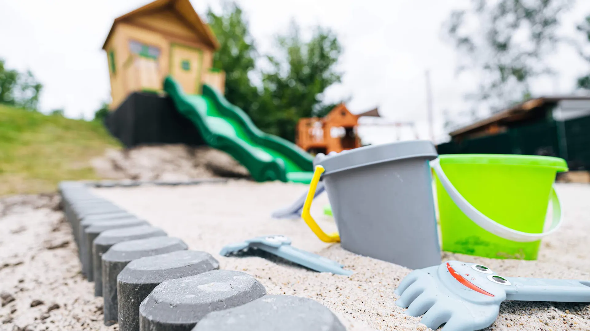 Spielhaus mit Sandkasten und Spielzeug