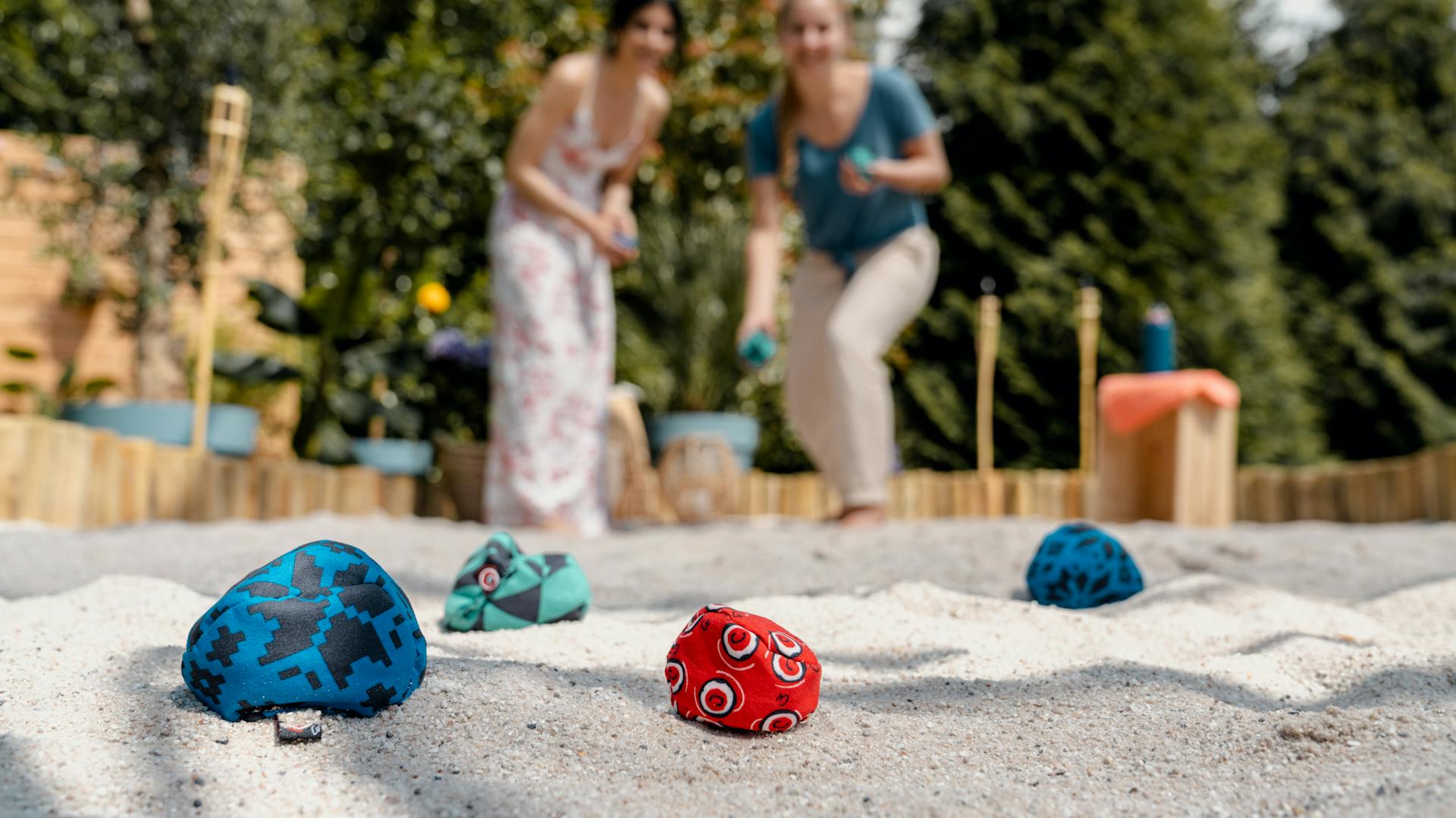 Frauen spielen Crossboule im Sand.