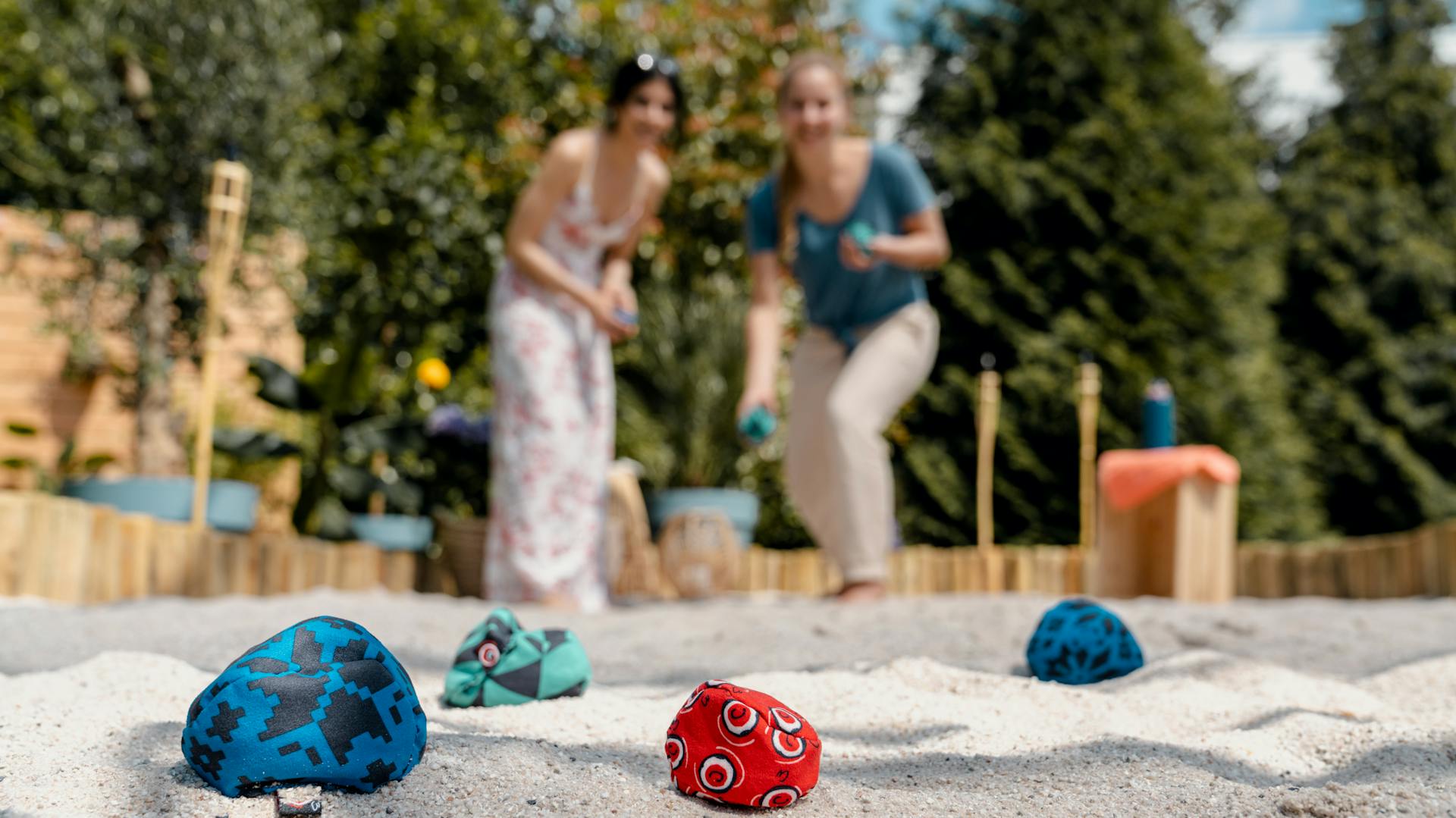 Frauen spielen Crossboule im Sand.