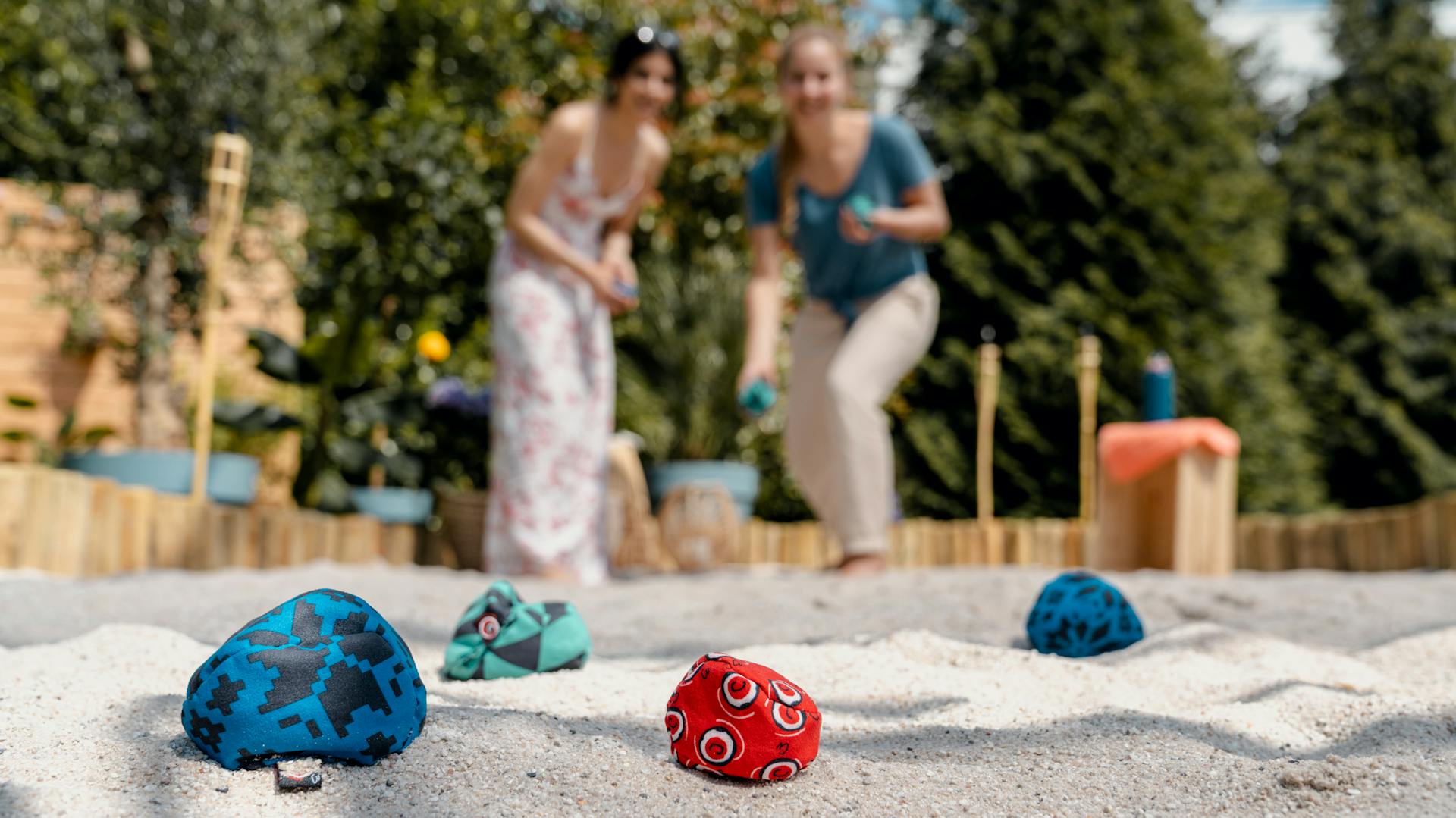 Freunde spielen Crossboule im Sand.