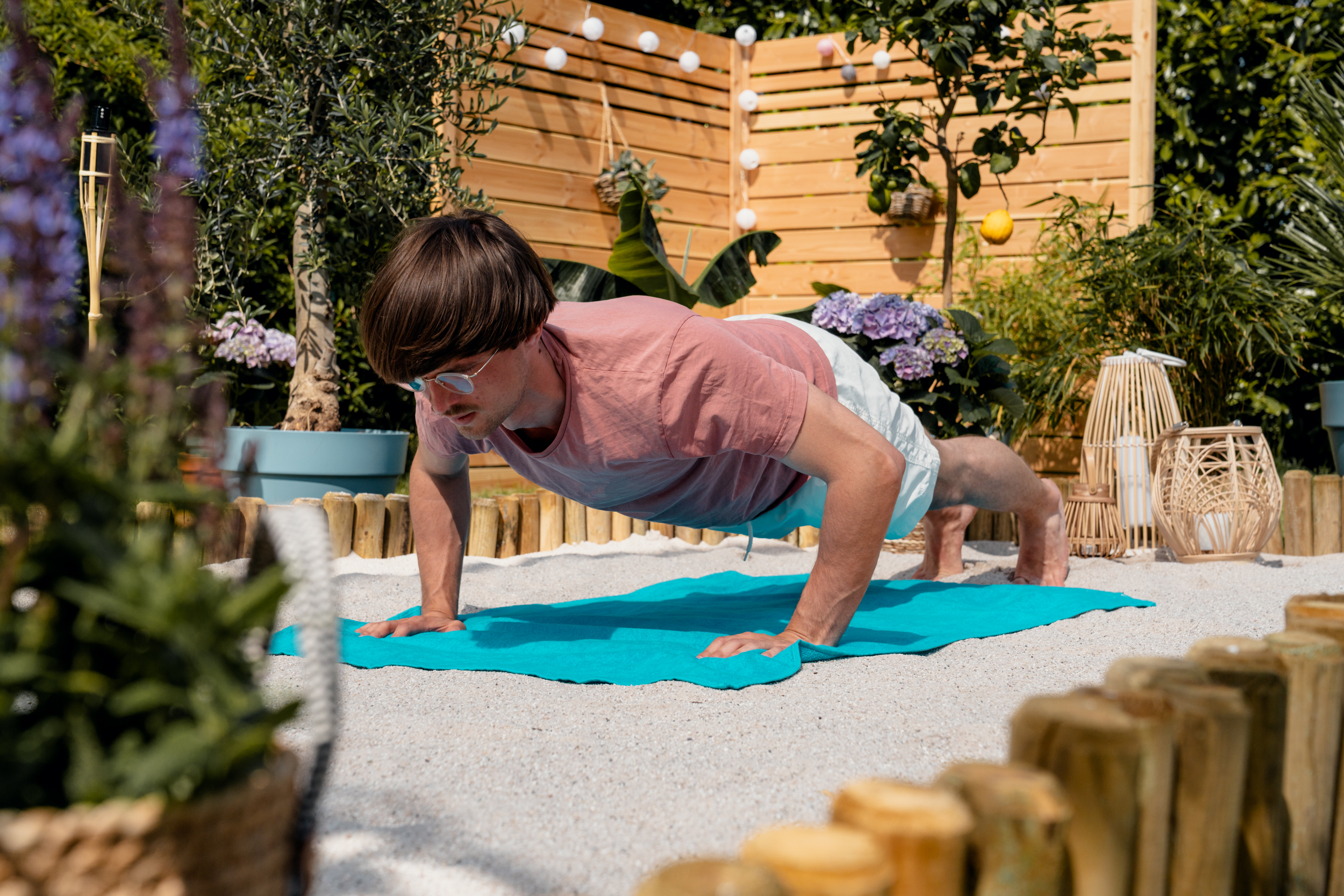 Un uomo si allena facendo flessioni sulla sabbia.