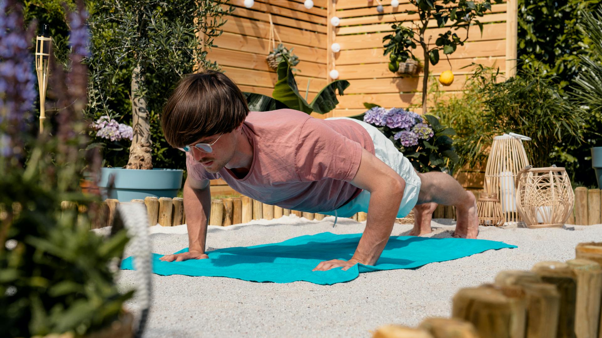 Mann macht Liegestütze für sein Fitnessprogramm im Sand.