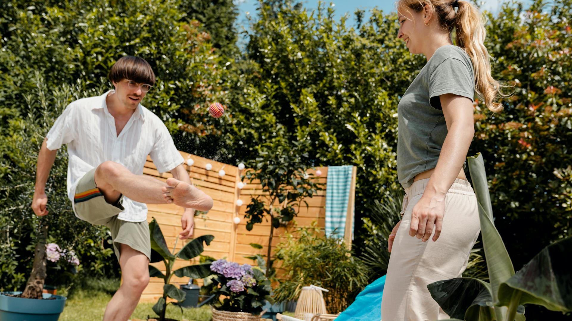 Freunde spielen Hacky-Sack oder Footbag im Sand.