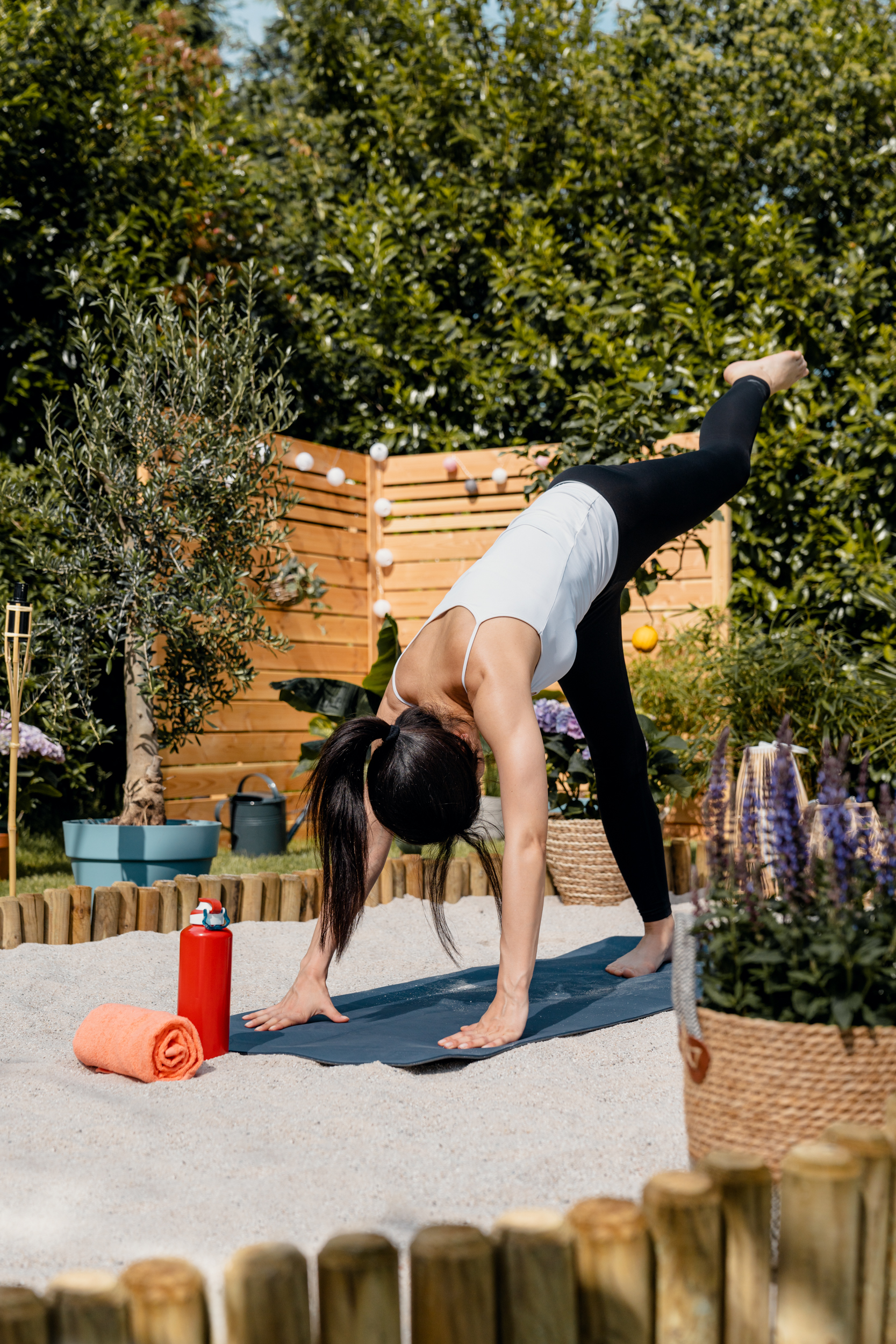 Una donna pratica yoga sulla sabbia.