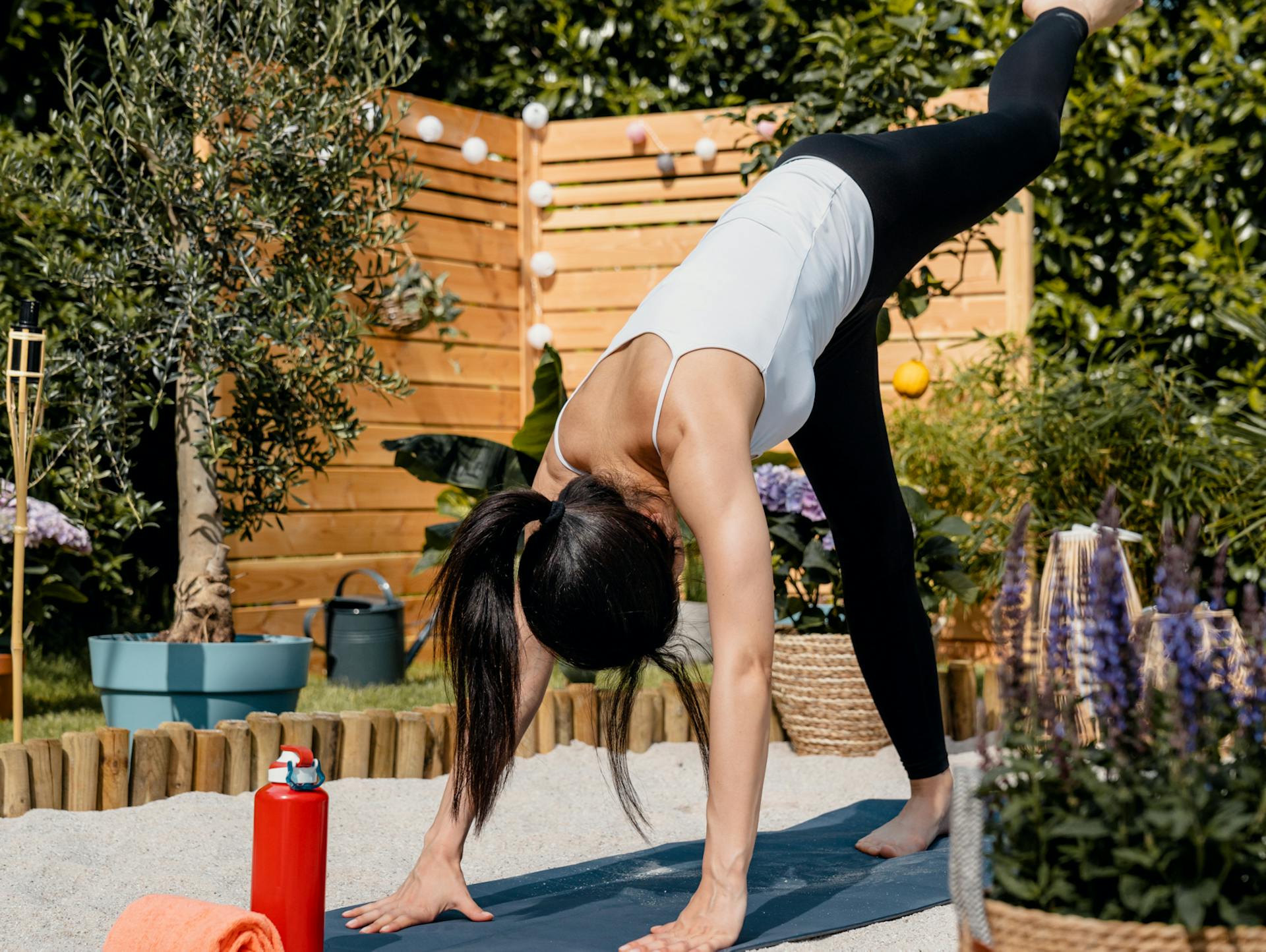 Frau übt Yoga im Sand.