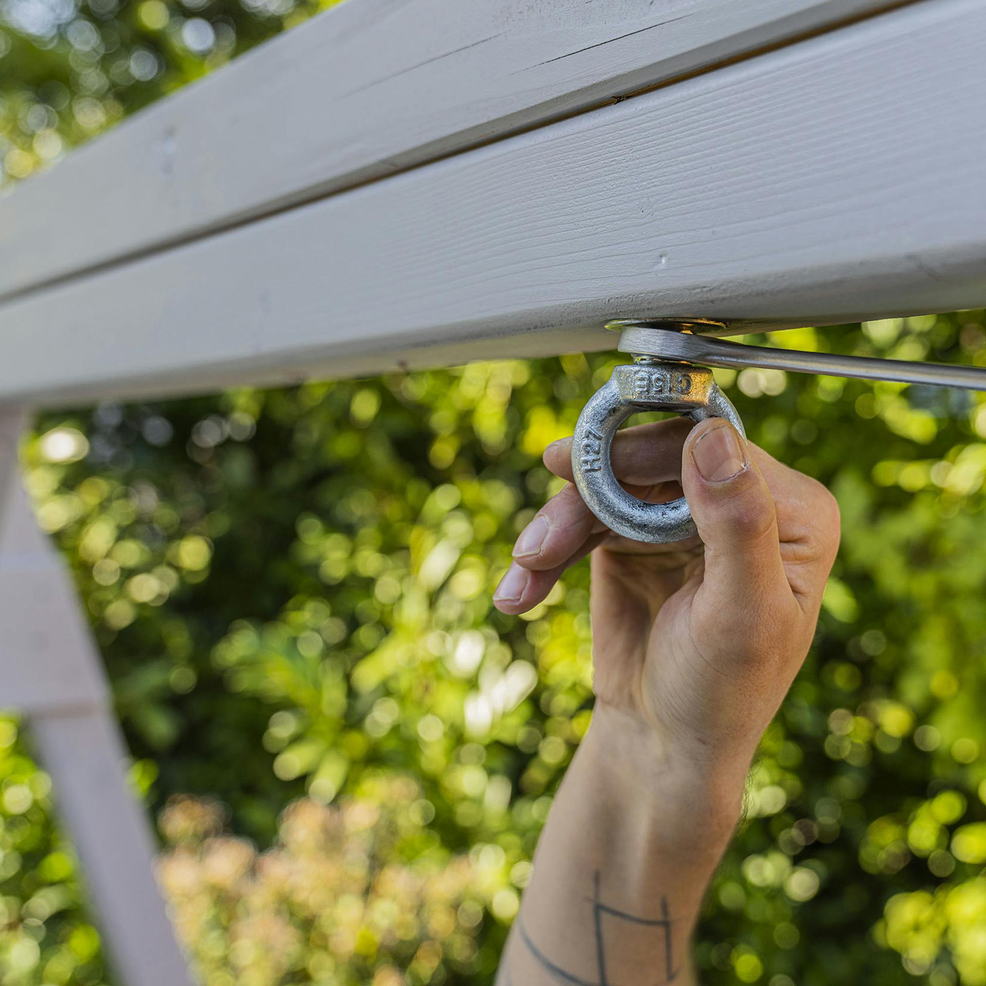 Handwerker befestigt Ringschraube in Schaukelgerüst.