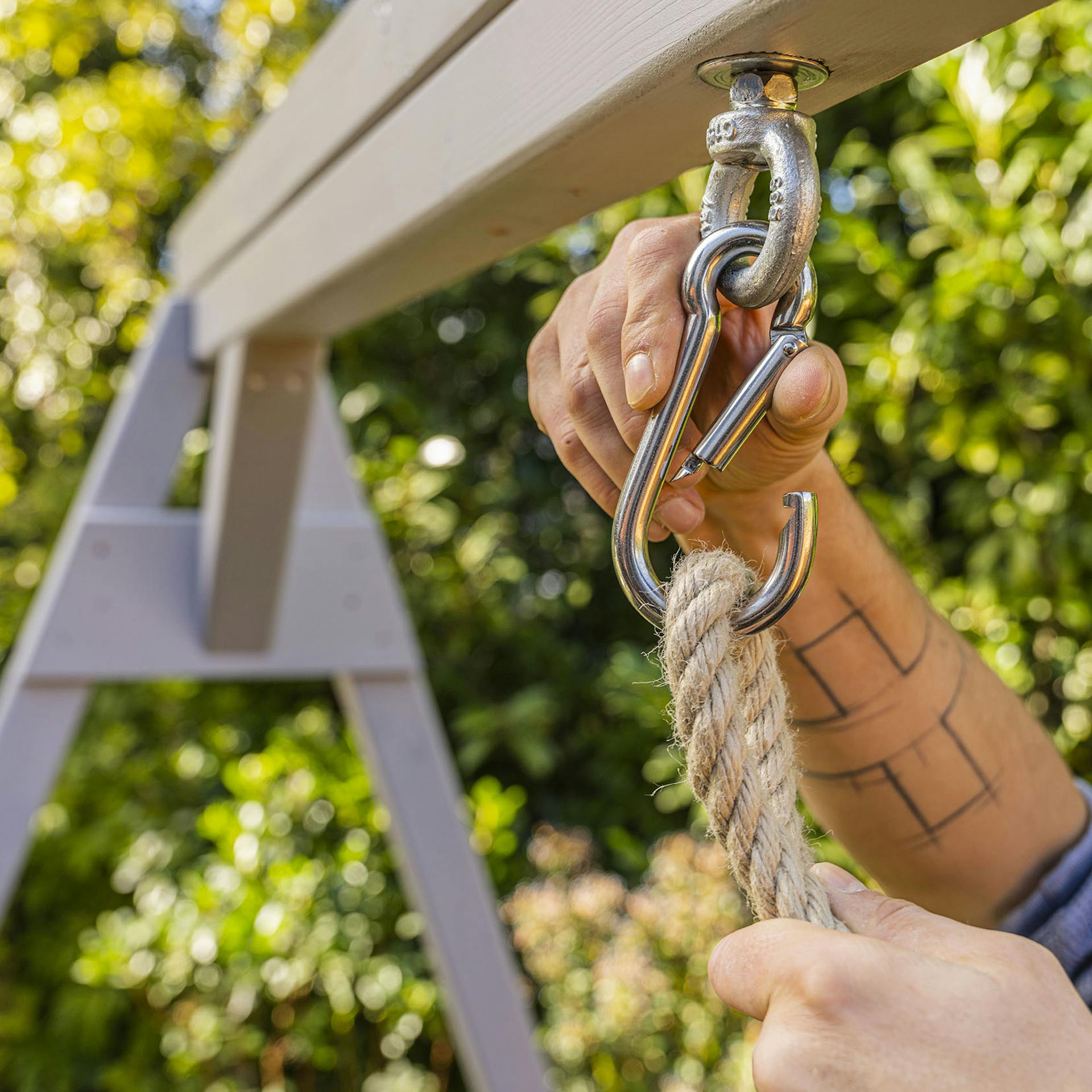 Handwerker hängt Seil in den Karabinerhaken.