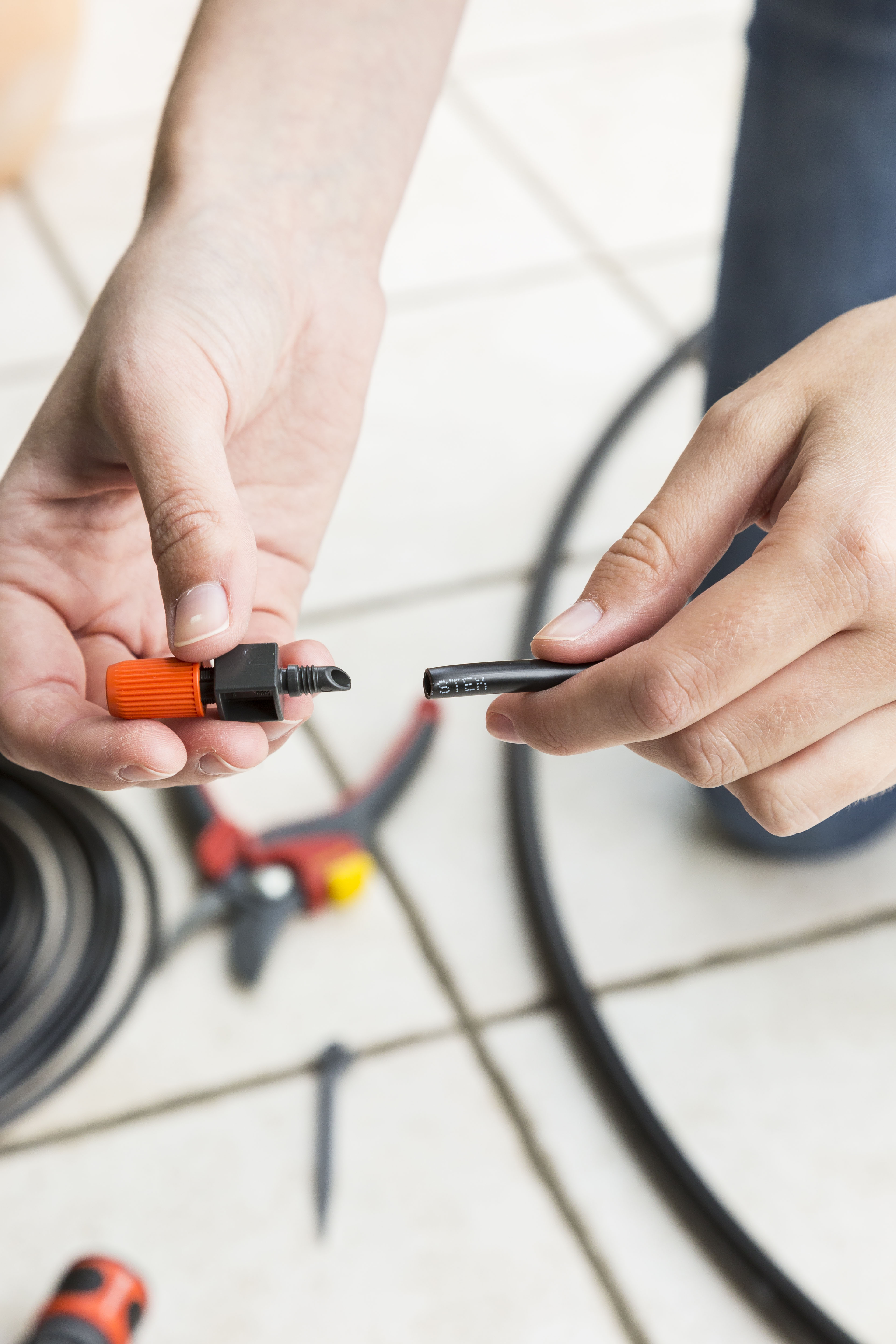 Una persona installa il gocciolatore dell’irrigazione a goccia.