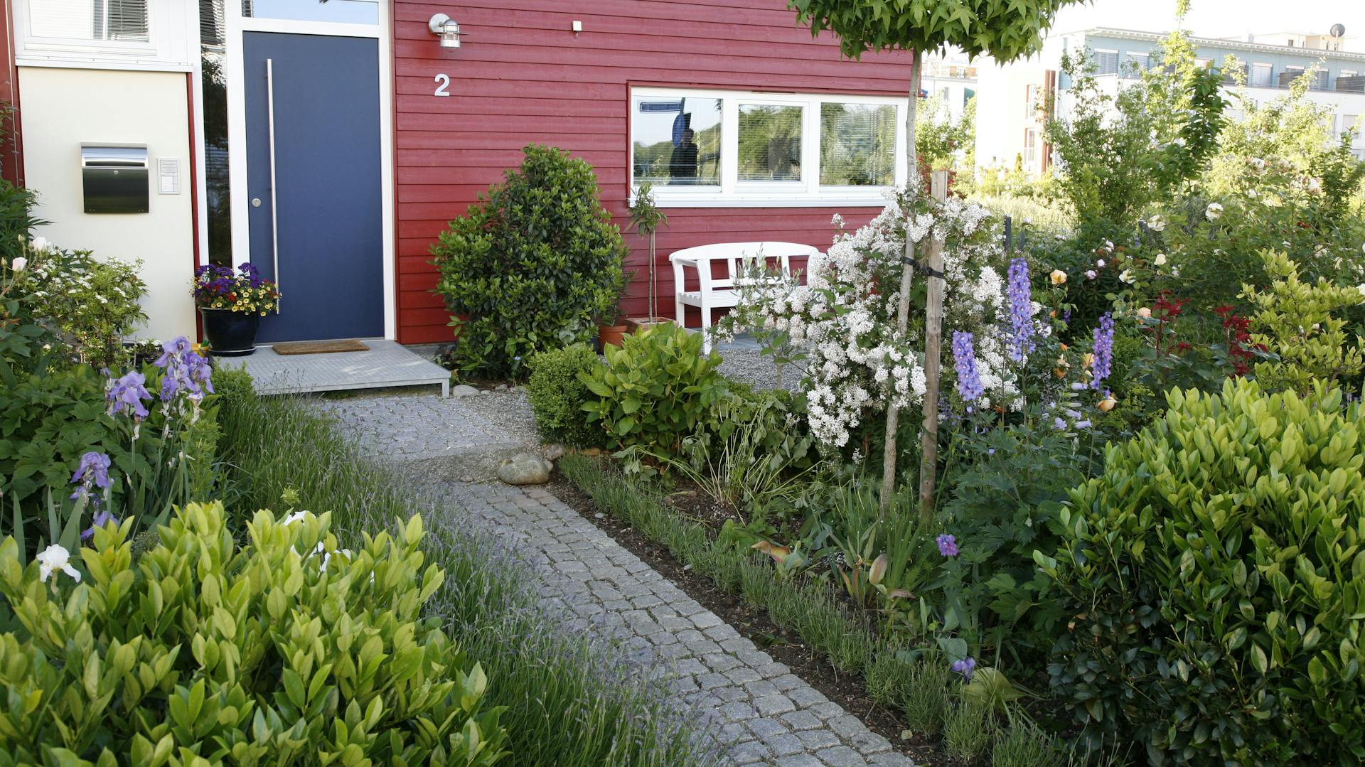 Vorgarten von einem roten Holzhaus