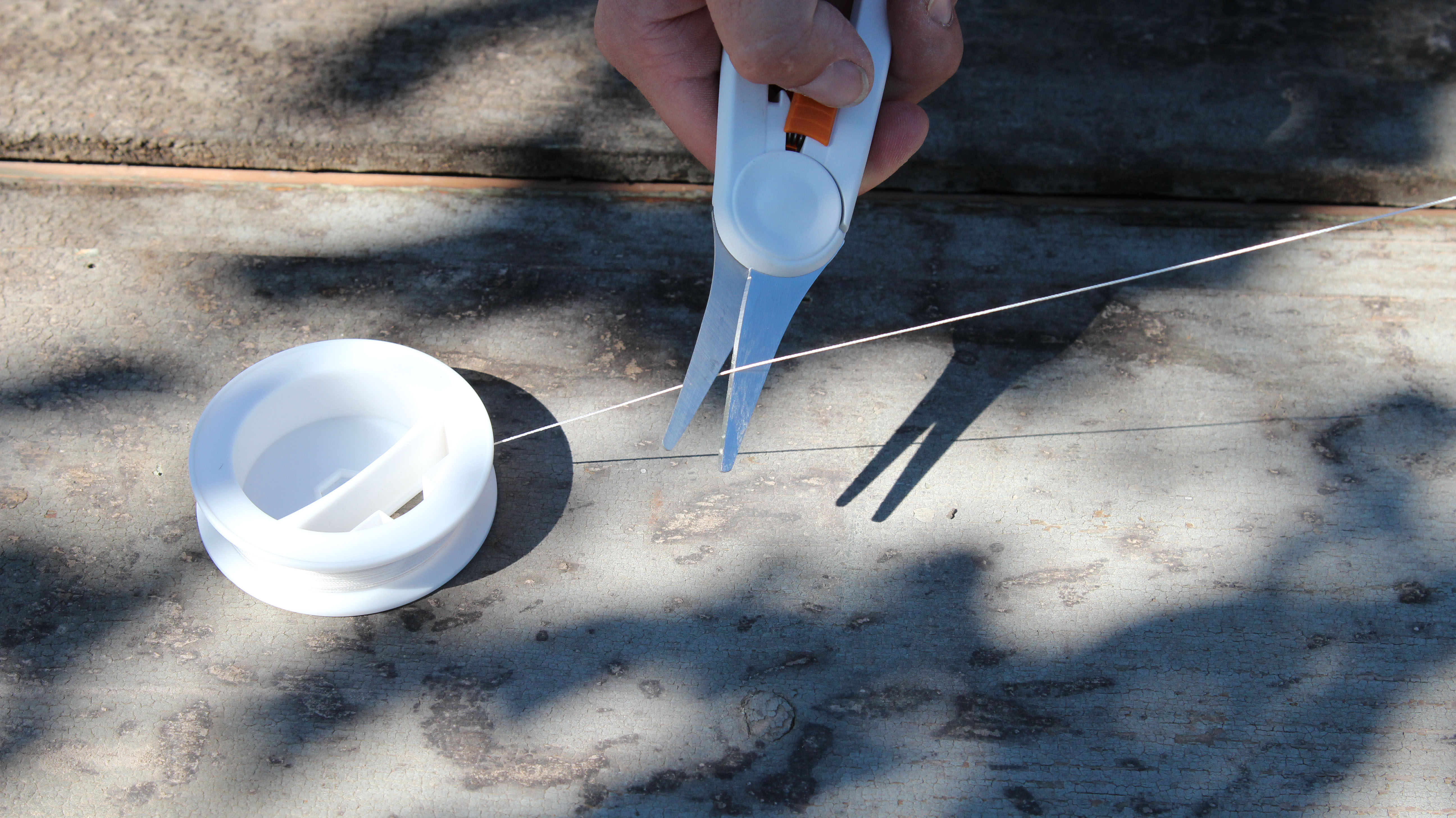 Un filo di nylon tagliato con le forbici.
